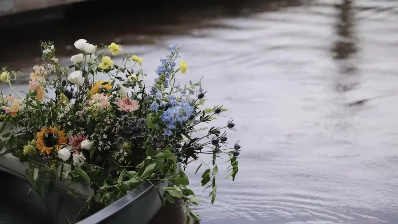 Sunflowers, blue delphinium, and wildflowers overflowing from a canoe on Piney Lake