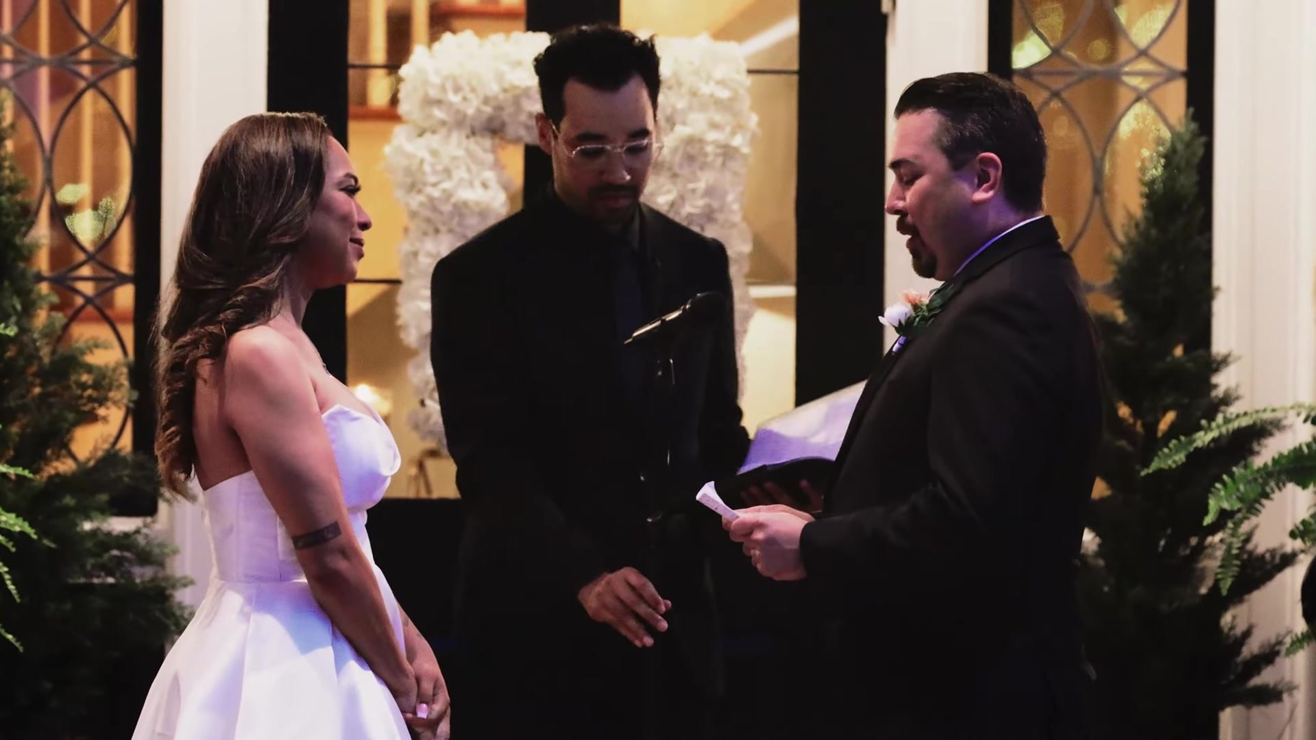 Blair and Gustavo exchanging vows at Southern Oaks Plantation in New Orleans with white florals behind them