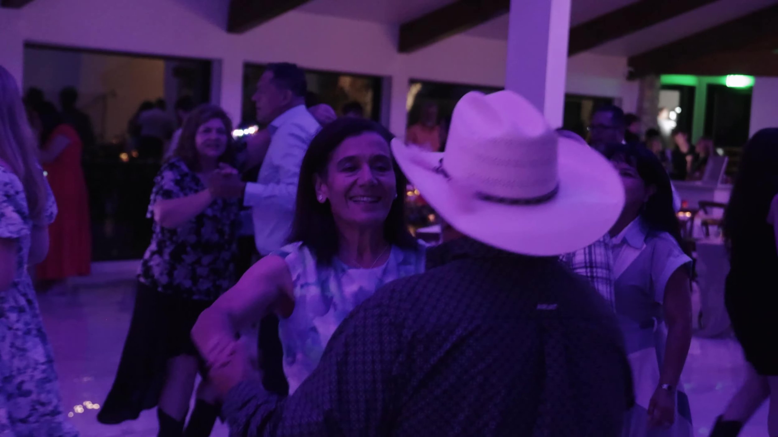 Guests dancing under purple party lights at Videre Estate luxury wedding reception near Austin