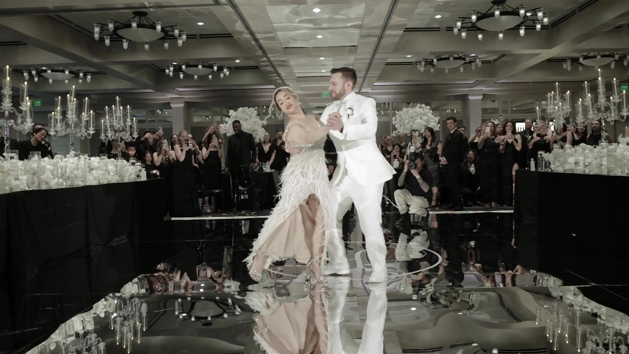 Keely and Jay first dance on a mirrored black floor in black and white decor at Barton Creek Austin