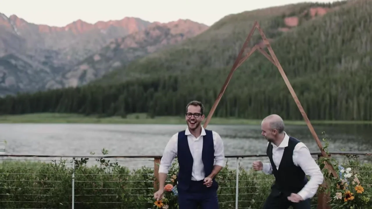 Patrick and Jake dancing on the lakeside deck at Piney River Ranch with Piney Lake and the Gore Range