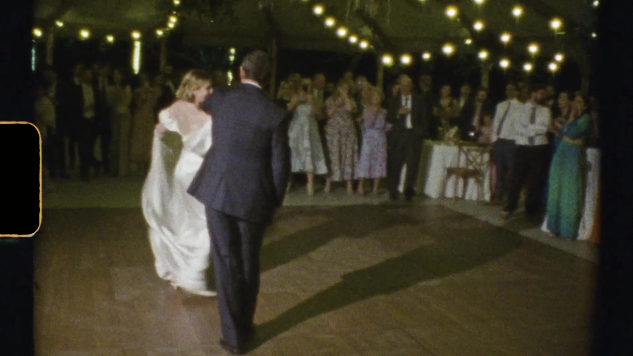 Sarah and her partner first dance under string lights at Camp Lucy Vineyards in Austin, Texas