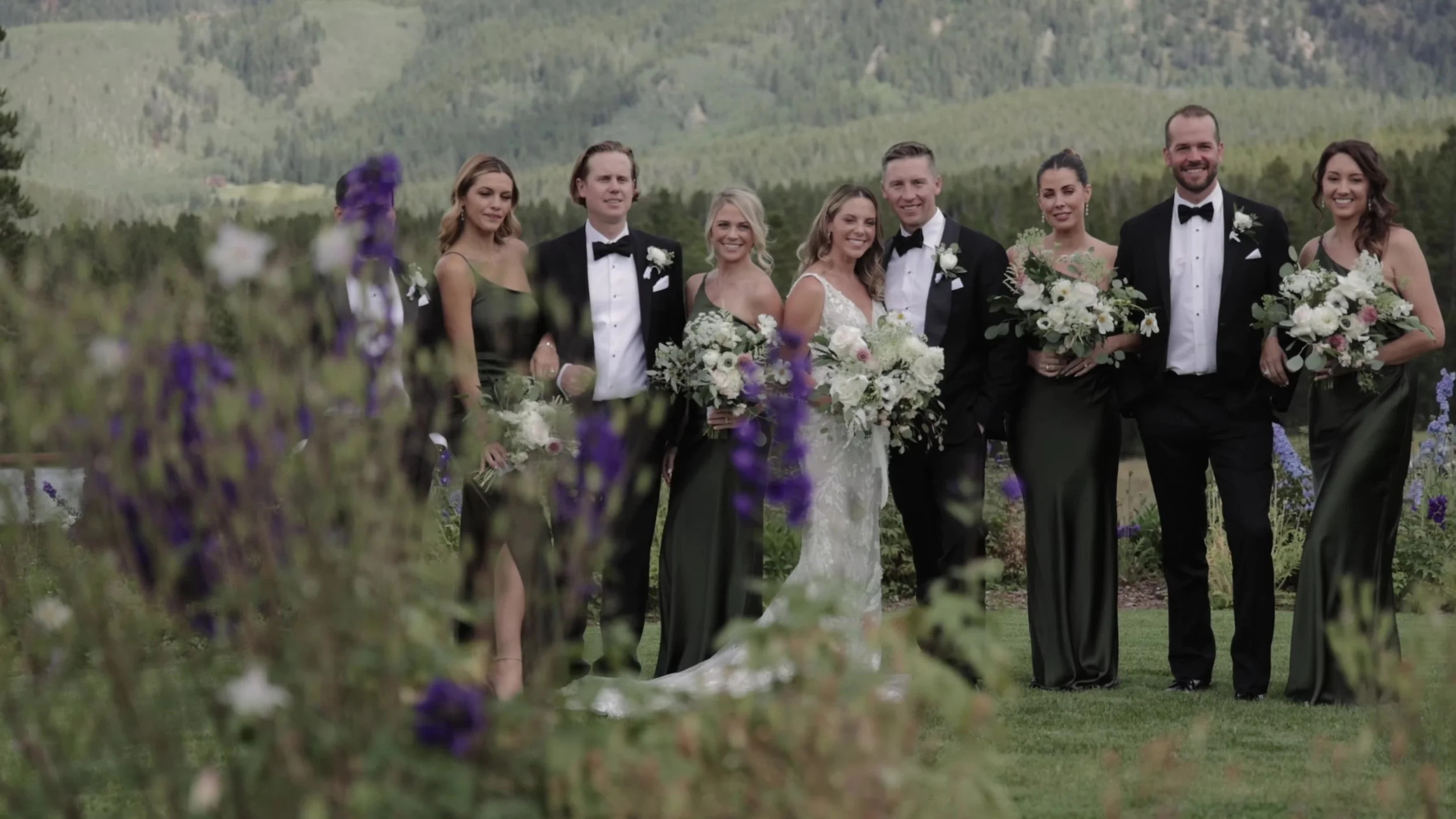 Caitlin and Matthew with their wedding party in a mountain field in Breckenridge, Colorado