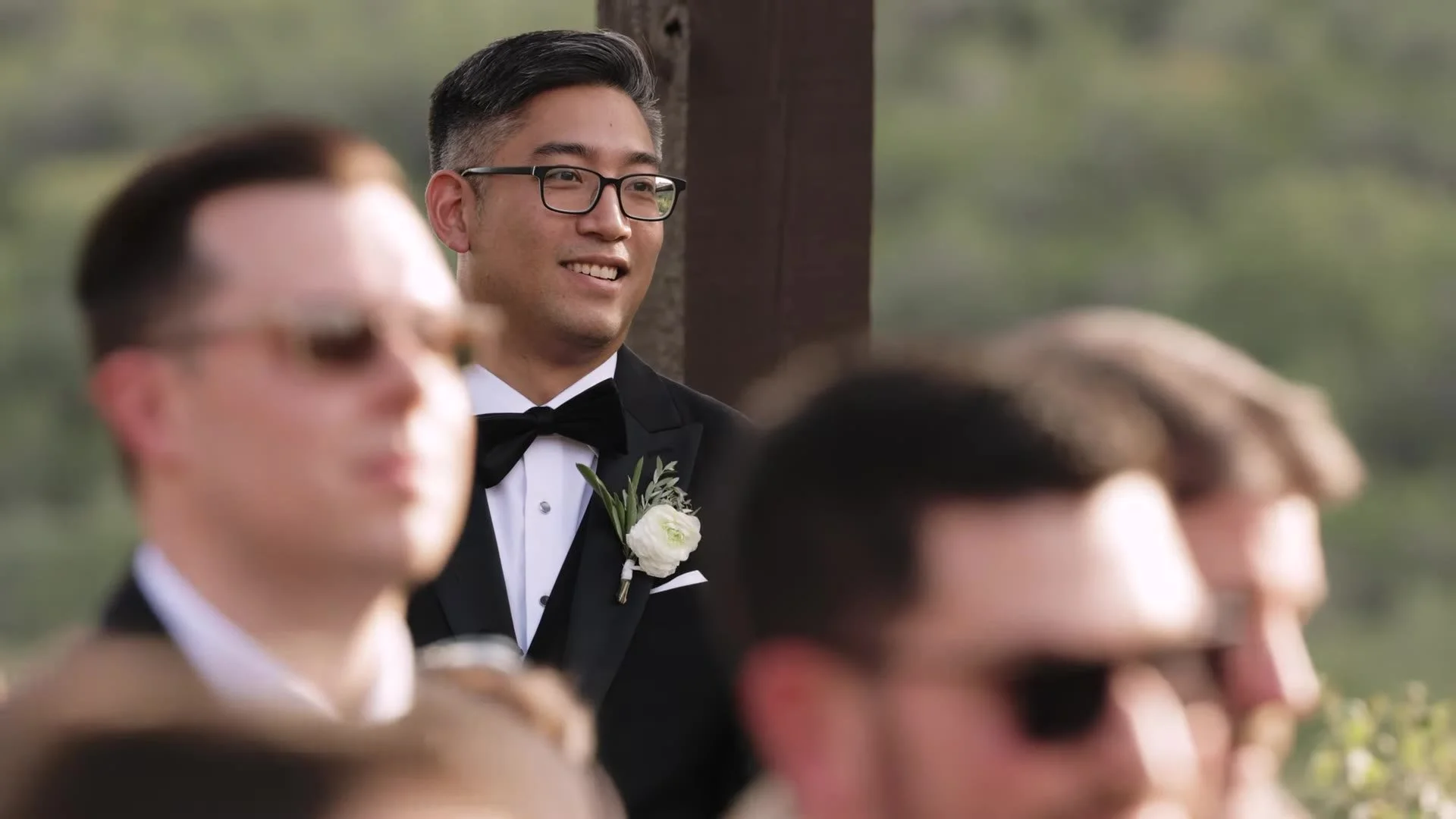 Jason smiling during the outdoor ceremony at Canyonwood Ridge with Austin Hill Country hills behind him