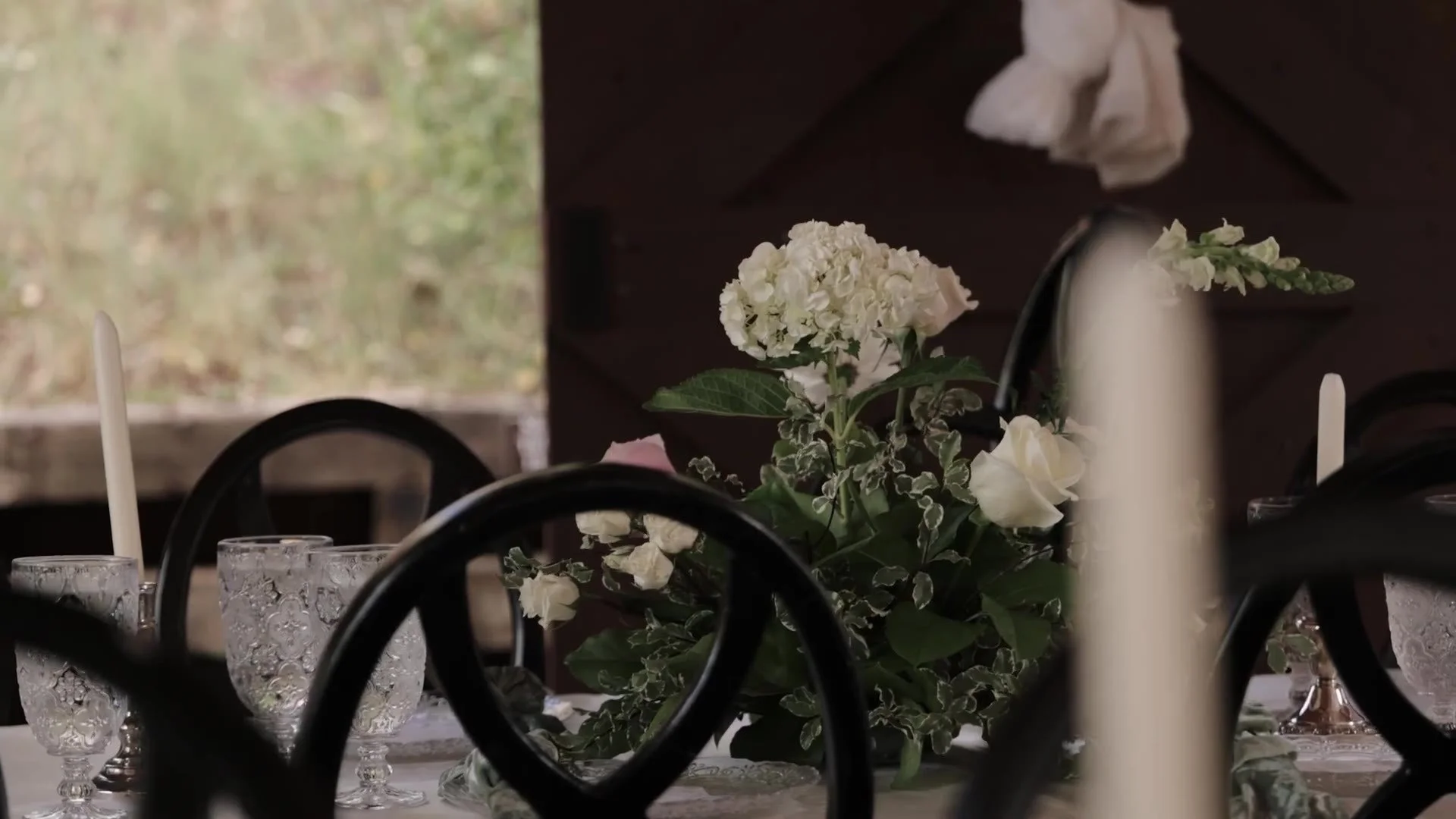 White hydrangea and rose centerpiece with taper candles at Crested Butte Wedding Garden in Colorado