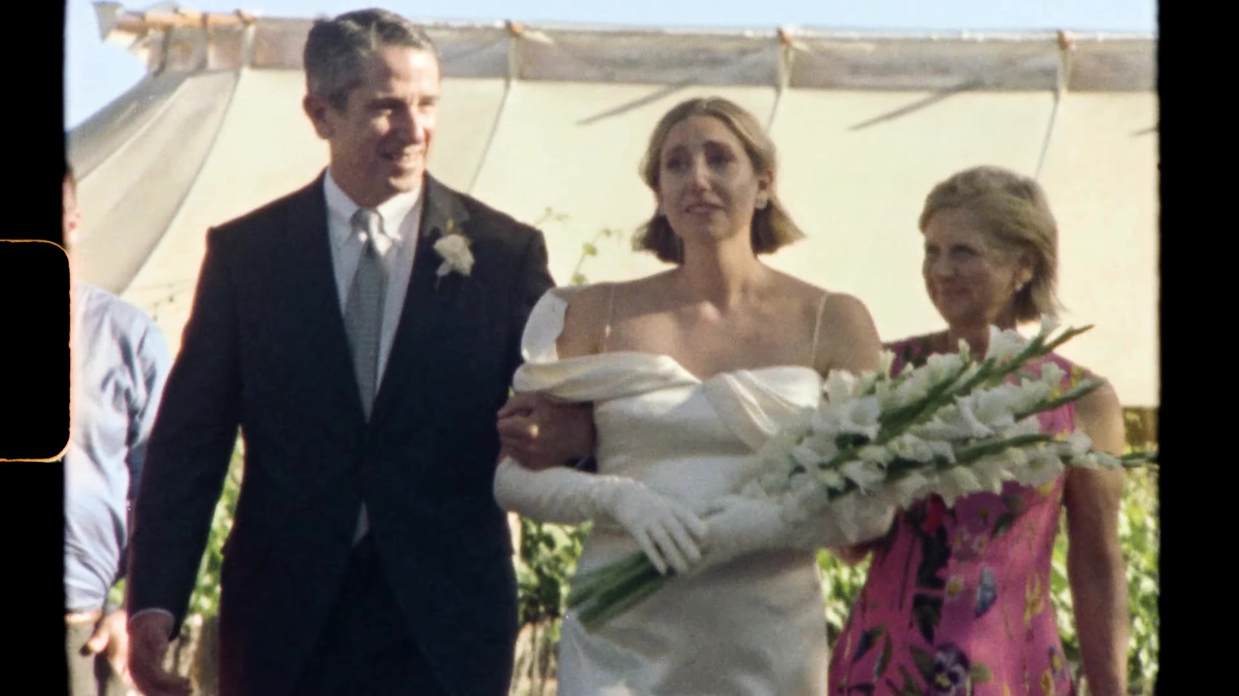 Sarah walking the white aisle through vineyard ceremony seating at Camp Lucy Vineyards in Austin, Texas