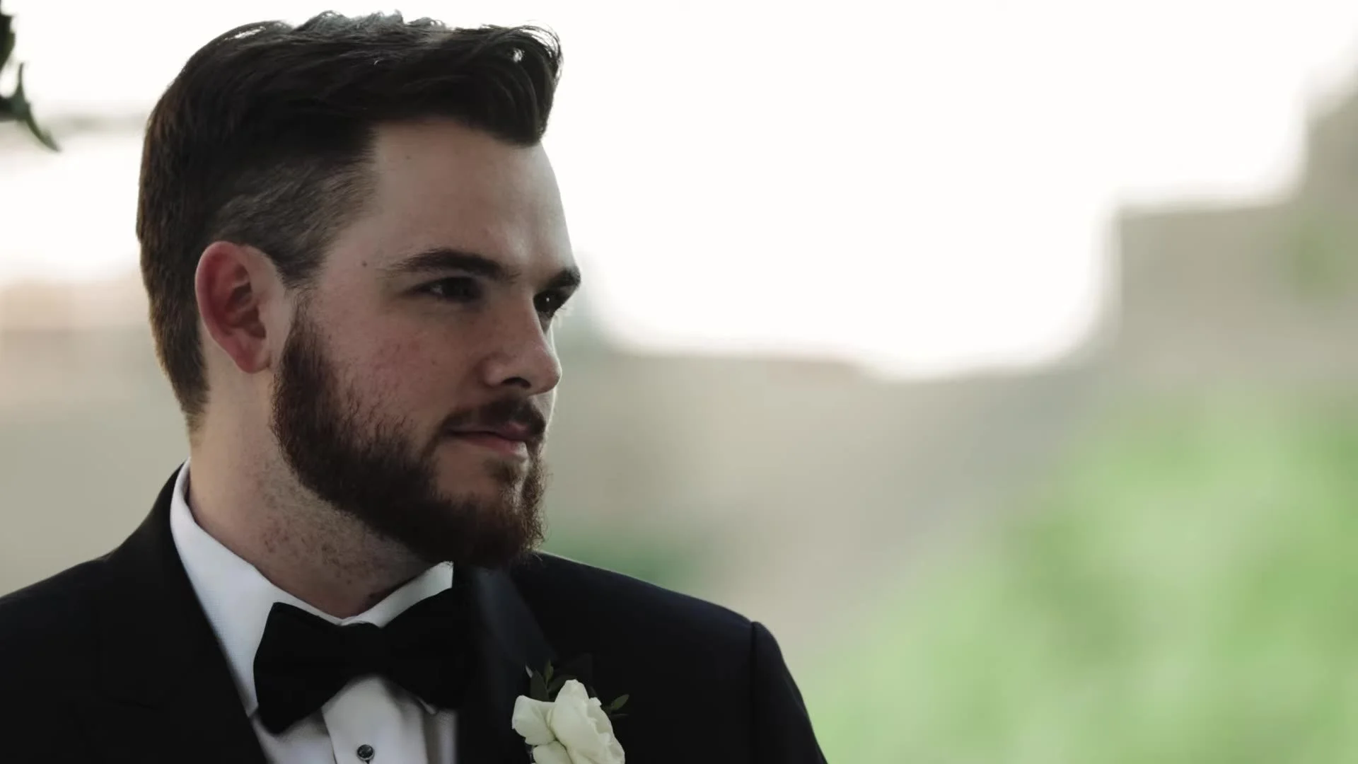 Nic in a black tuxedo and bow tie with a white boutonniere at Q2 Stadium in Austin, Texas