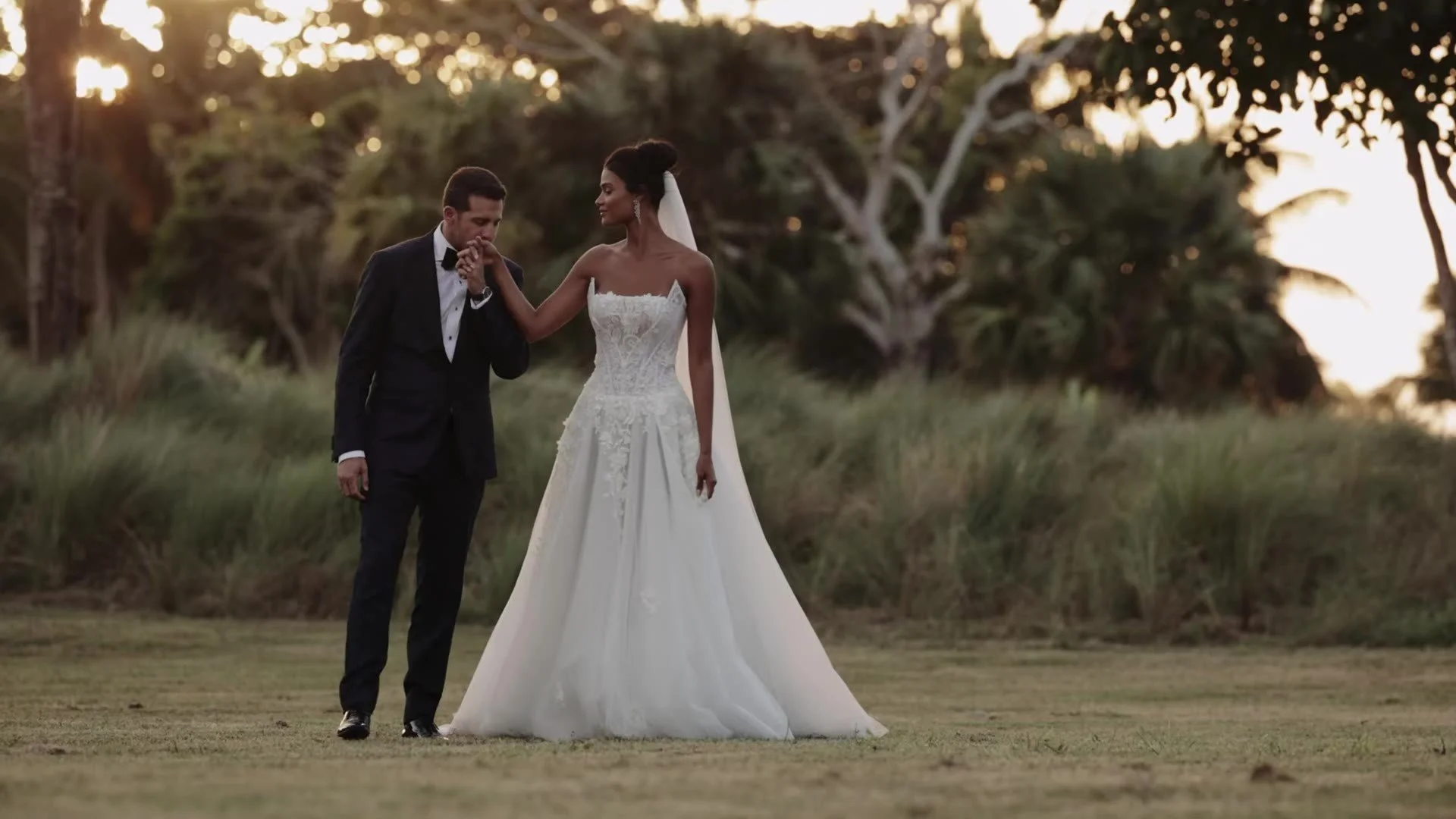 Adam kissing Daniela hand in a field at Amanera Dominican Republic