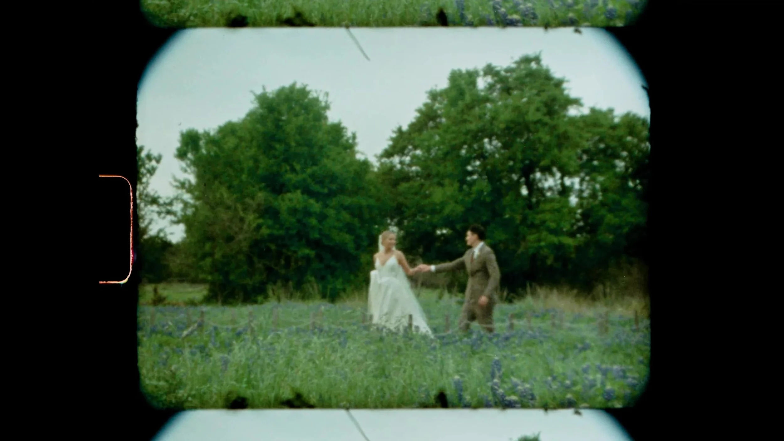 Heather and Chris walking through bluebonnets in a Super 8 frame at Lady Bird Johnson Wildflower Center in Austin, Texas