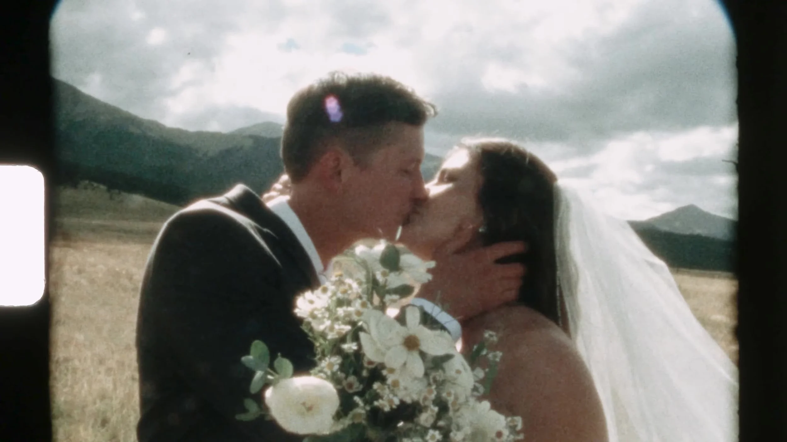 Super 8 kiss of Seth and Cass with a white bouquet at 3 Peaks Ranch in Colorado