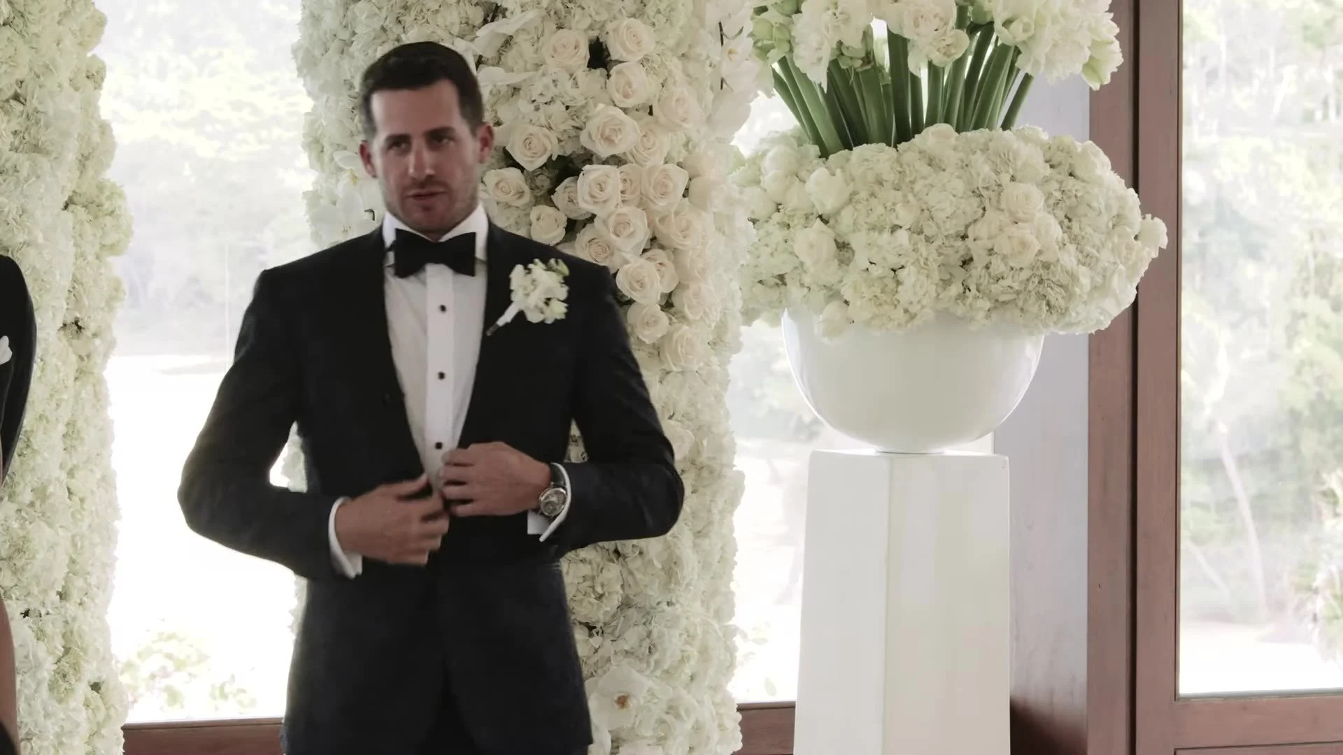 Adam in tuxedo adjusting jacket at the floral altar Amanera Dominican Republic
