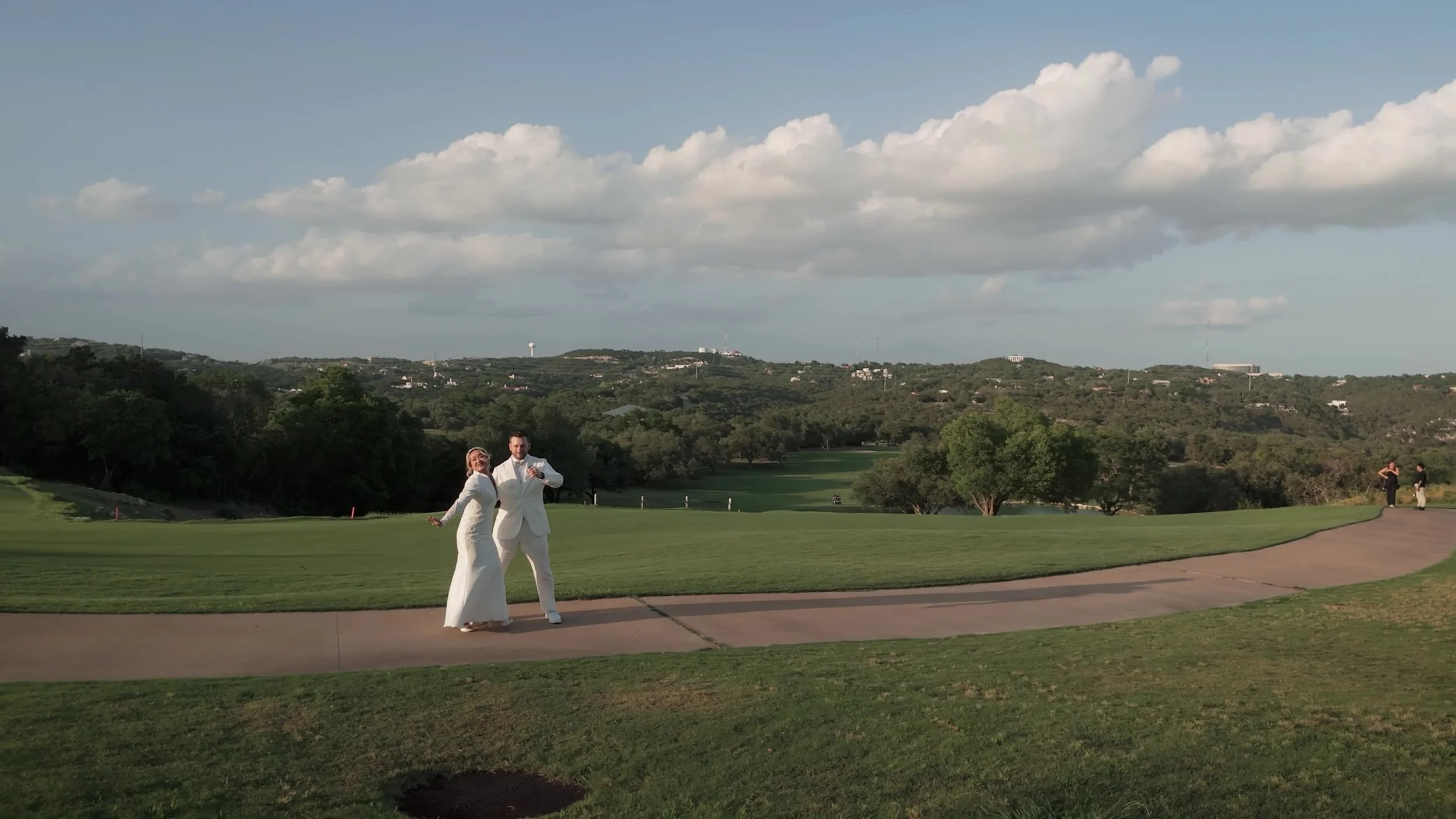 Keely and Jay walking a path across the golf course at Barton Creek Country Club in Austin