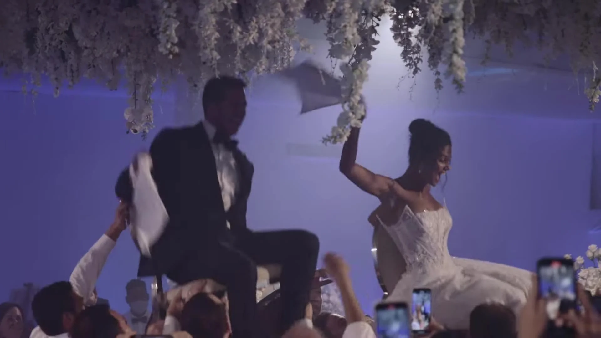 Daniela and Adam lifted on chairs under florals at Amanera Dominican Republic