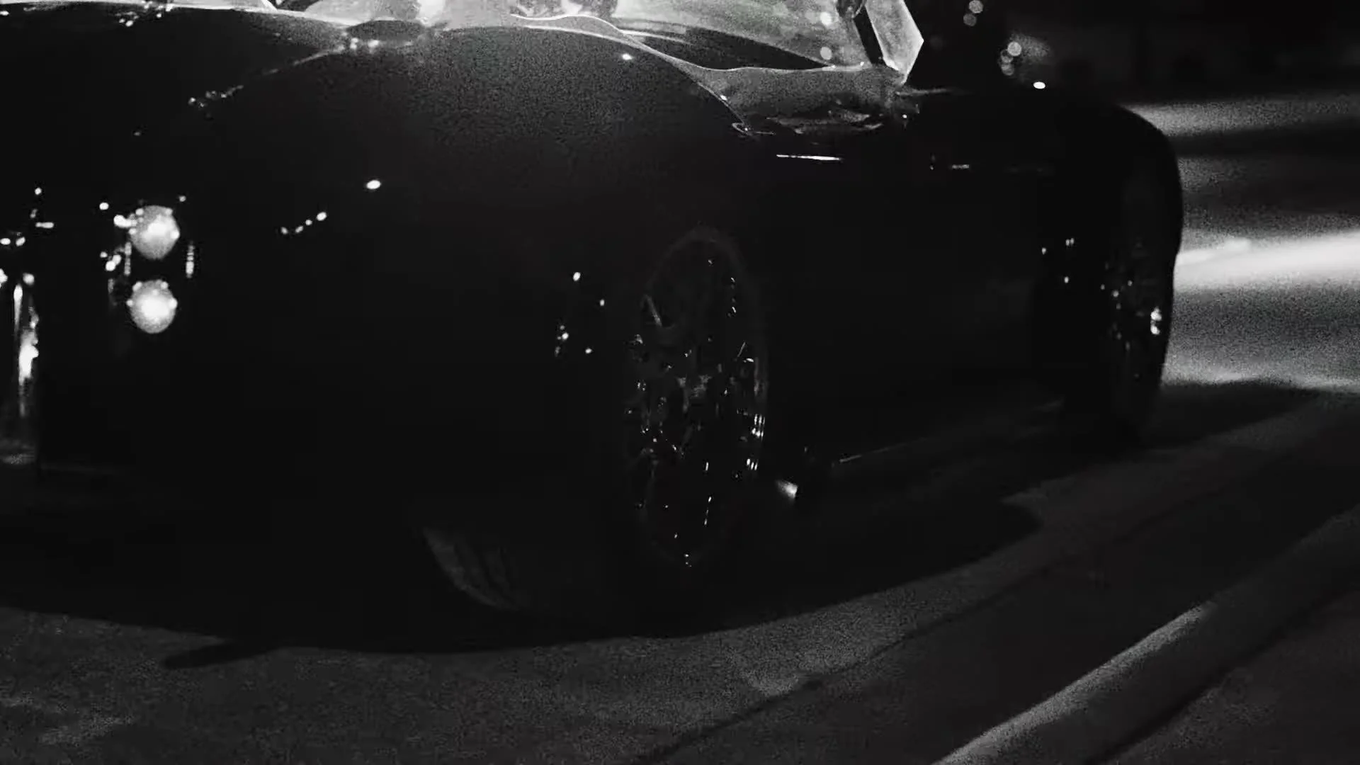 Grainy Super 8 night frame of a classic Cobra convertible on an Austin Texas street
