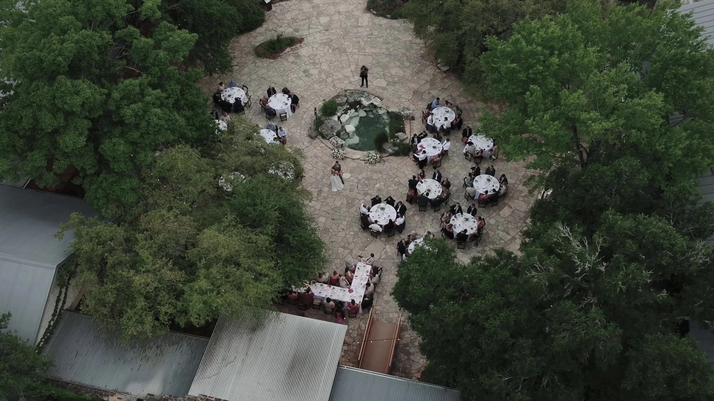Aerial view of the outdoor reception courtyard with round tables at Lady Bird Johnson Wildflower Center in Austin, Texas