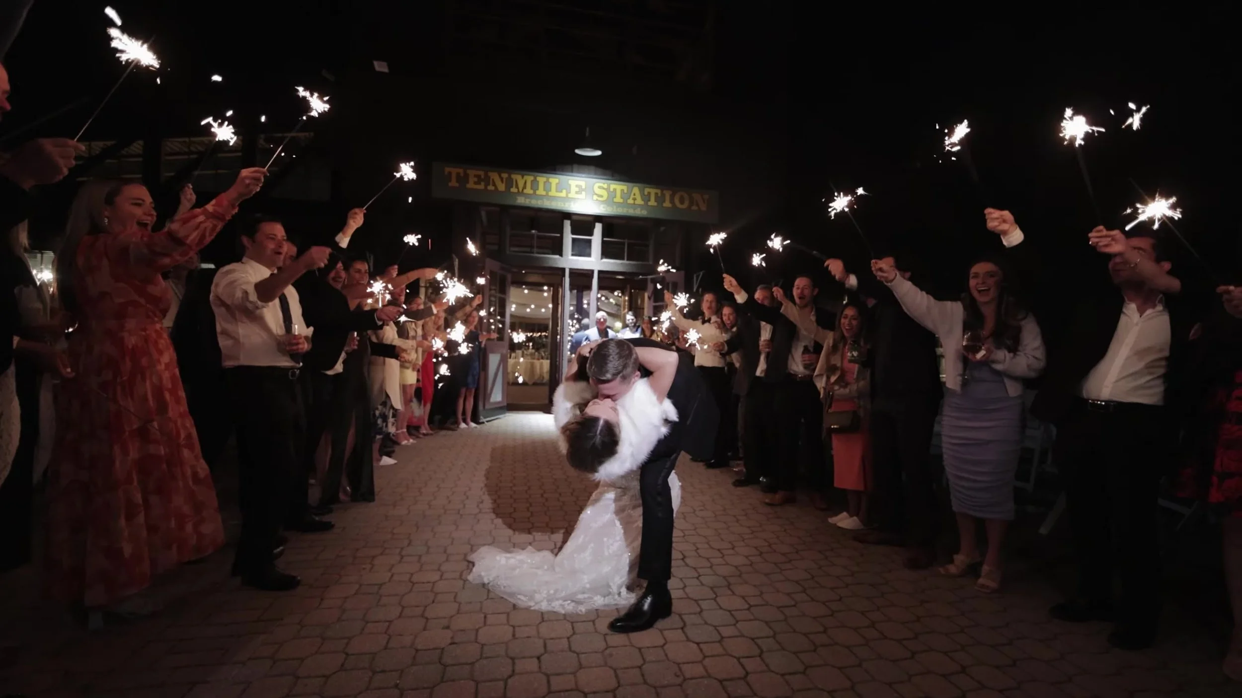 Caitlin and Matthew kiss under sparklers at Ten Mile Station in Breckenridge, Colorado