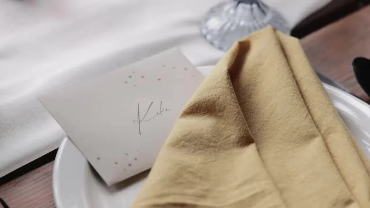 Place setting at Piney River Ranch, white plate, mustard napkin, and a handwritten place card