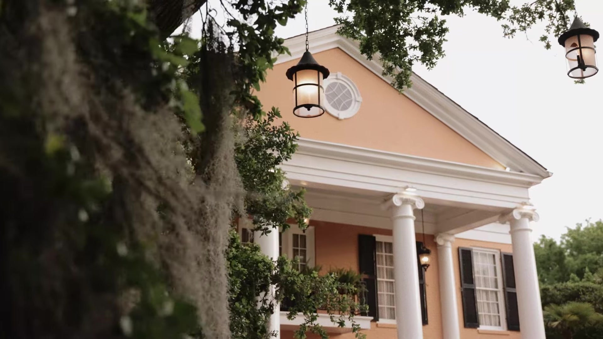 Southern Oaks Plantation mansion in New Orleans with white columns, Spanish moss, and glowing lanterns in the oaks