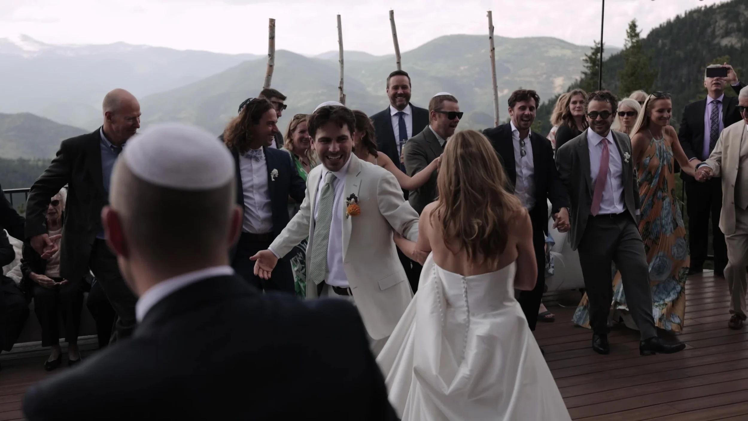 Guests dancing with the couple on the outdoor deck at Northstar Gatherings in Idaho Springs, Colorado, mountains in the background
