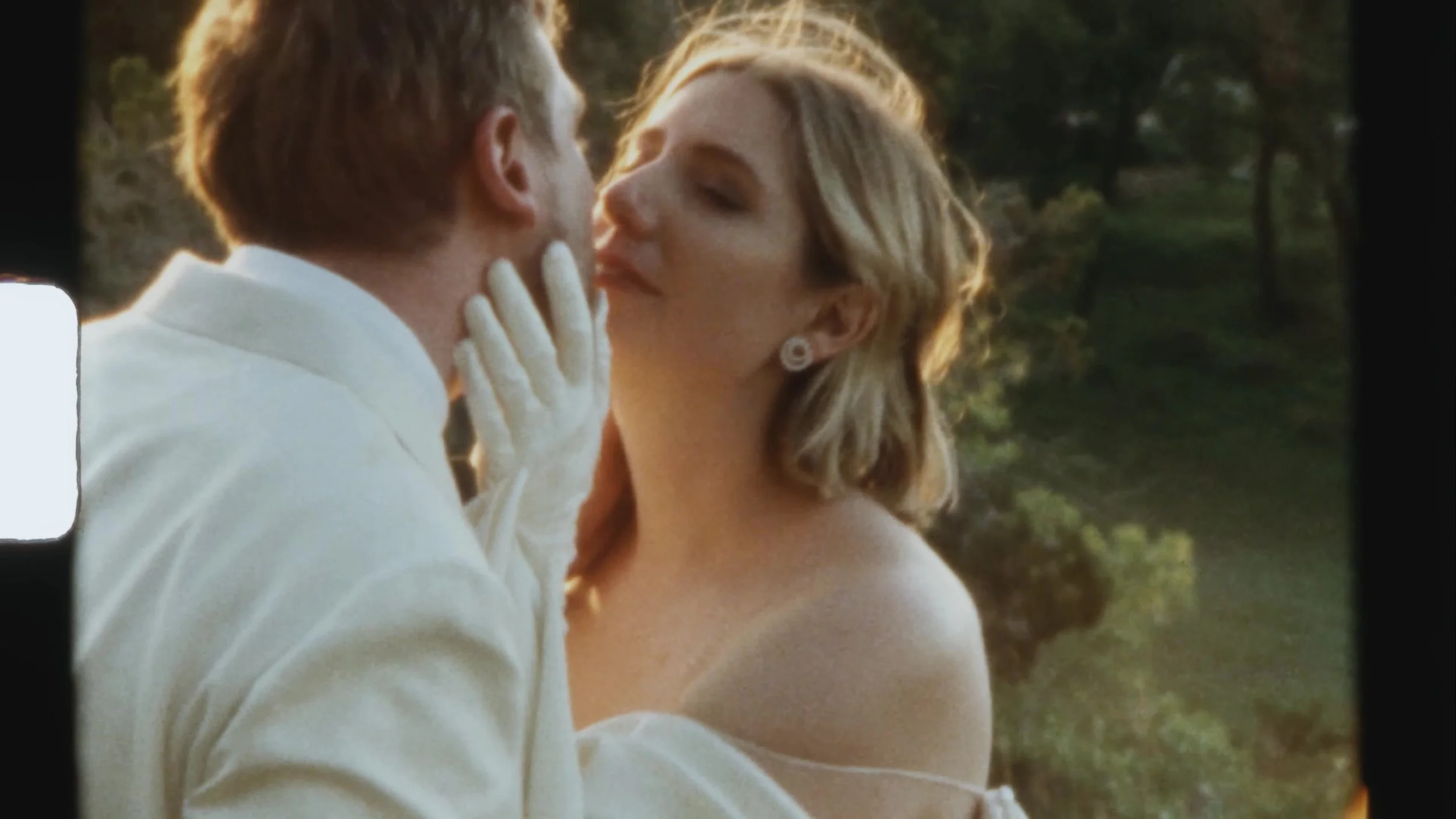 Super 8 close of Sarah with her partner in a kiss at Camp Lucy Vineyards in Austin, Texas