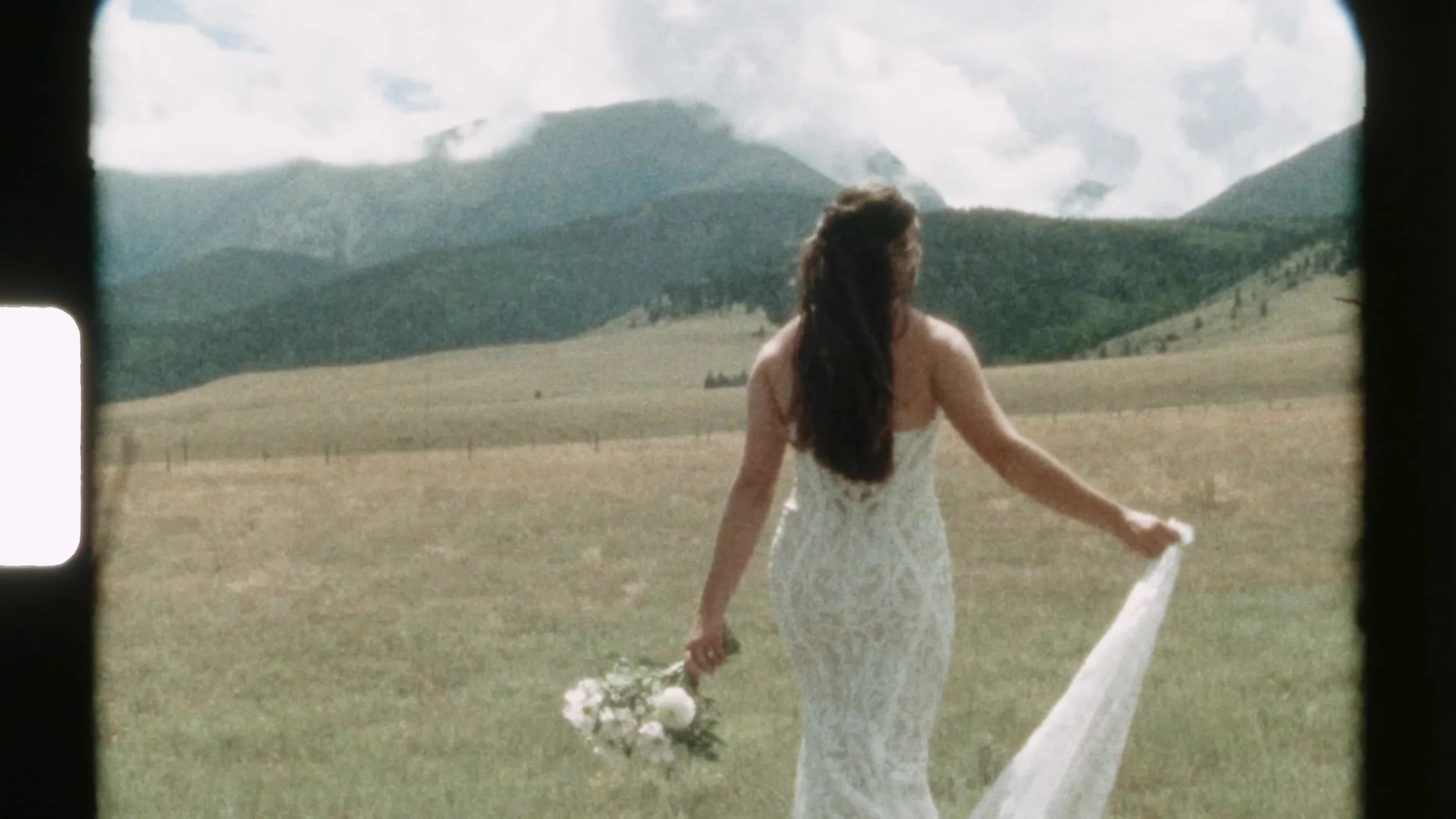 Super 8 frame of the bride walking toward the mountains at 3 Peaks Ranch in Westcliffe, Colorado