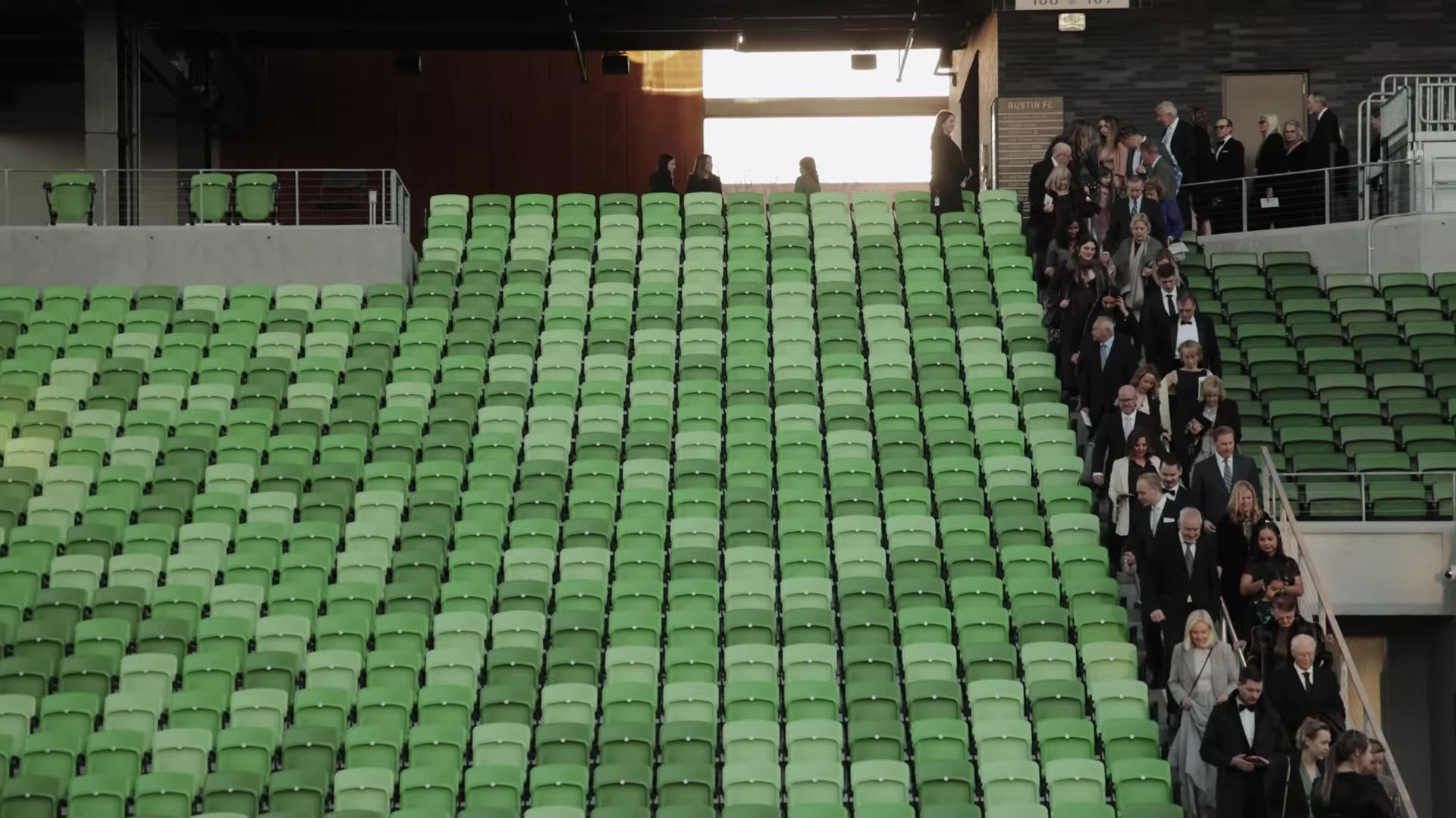Wedding guests walking down the green stadium stairs at Q2 Stadium in Austin, Texas