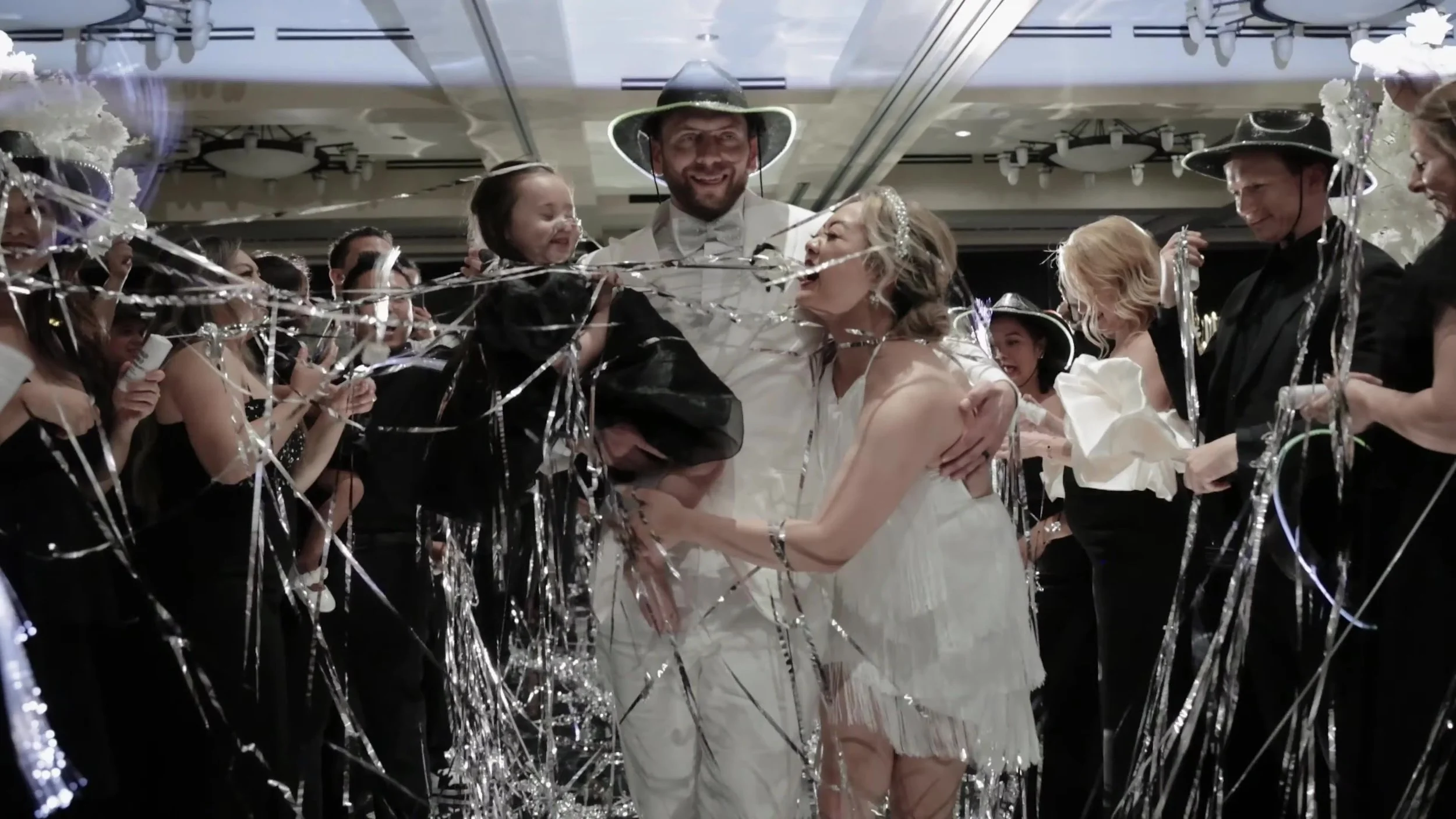 Keely and Jay laughing under silver streamers with guests at Barton Creek Country Club Austin