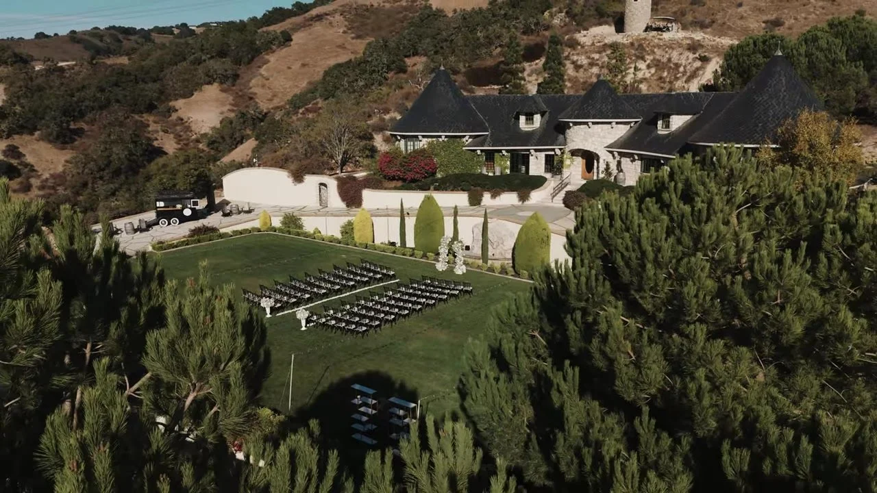 Aerial of the chateau, ceremony lawn, cypress, and golden SLO hills