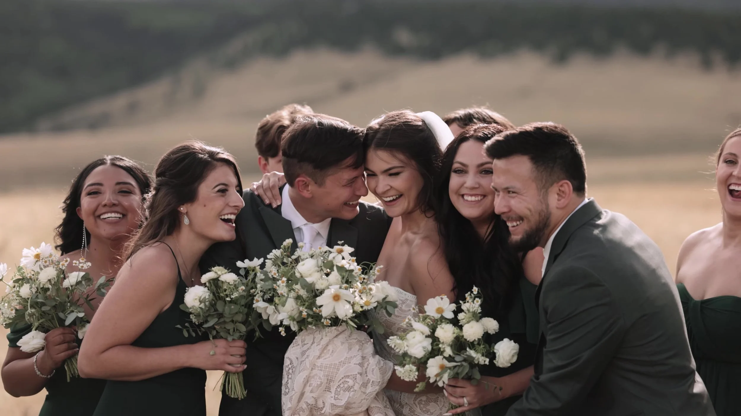 Seth and Cass laughing with their wedding party in a meadow at 3 Peaks Ranch in Colorado