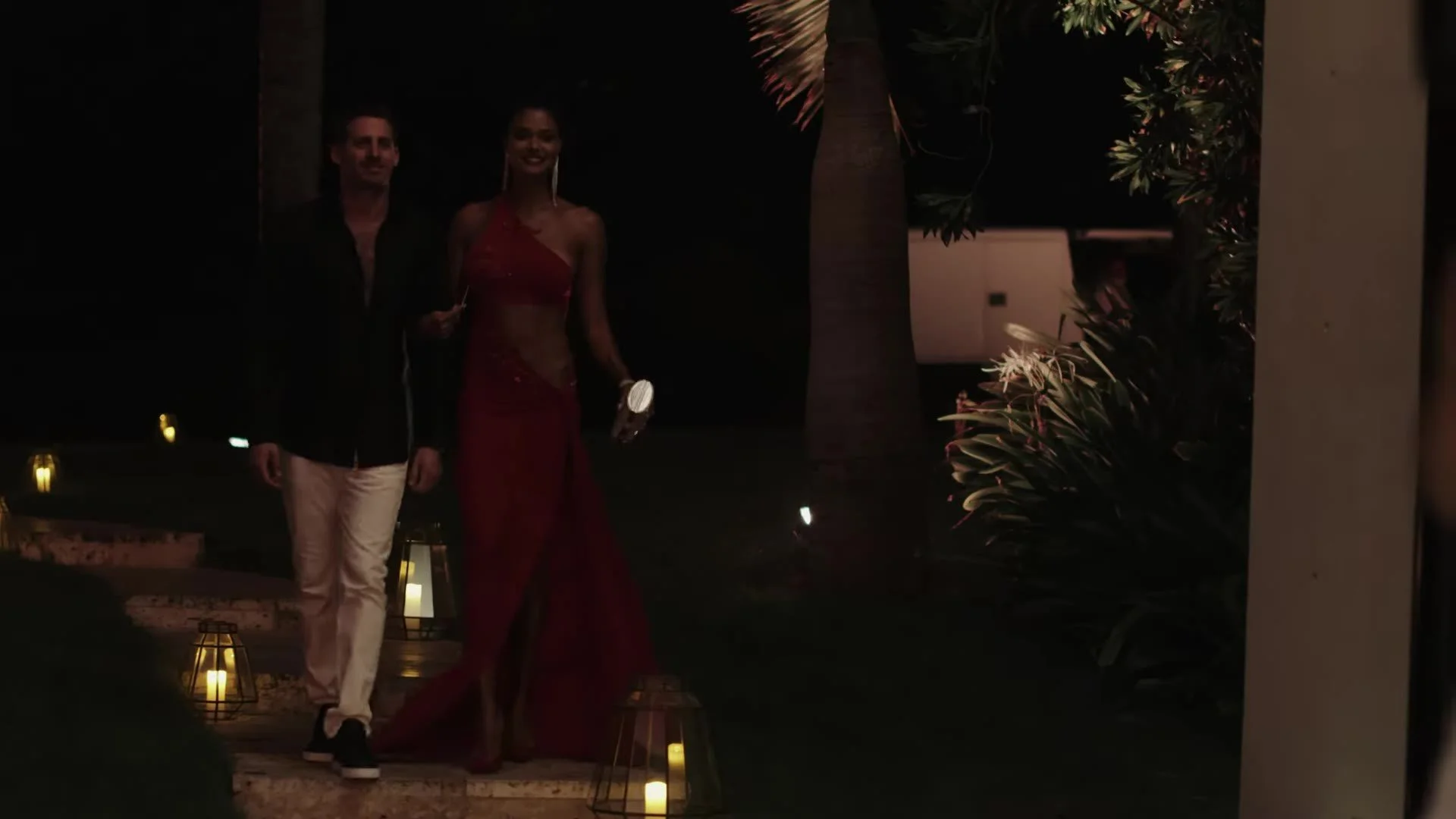 Daniela in red dress and Adam walking lantern path at Amanera Dominican Republic