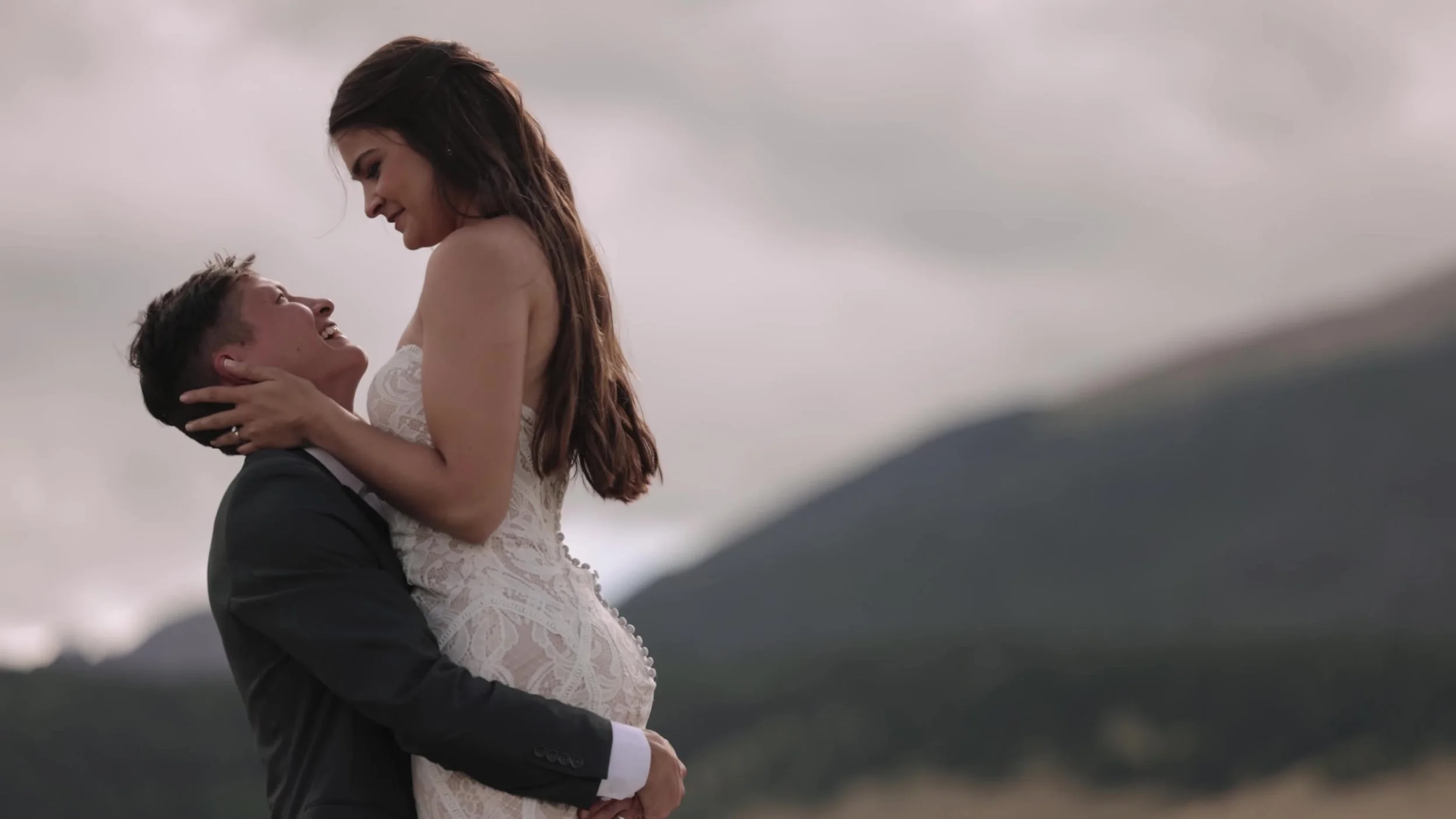 Groom lifting the bride in a field at 3 Peaks Ranch in Westcliffe, Colorado