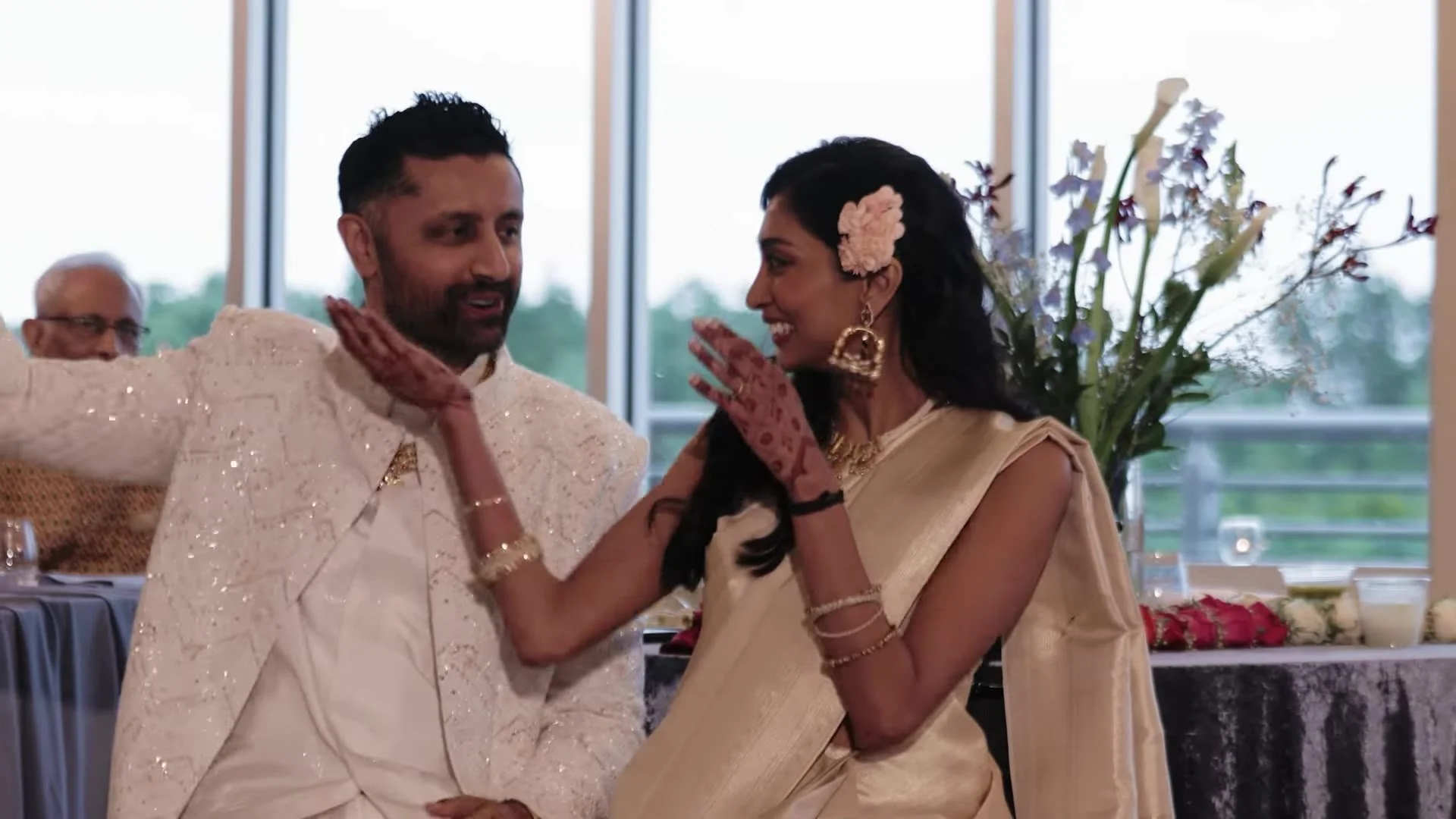 Bhavim and Mala in cream reception attire smiling at each other with mehndi visible at The Terrace Club in Austin, Texas