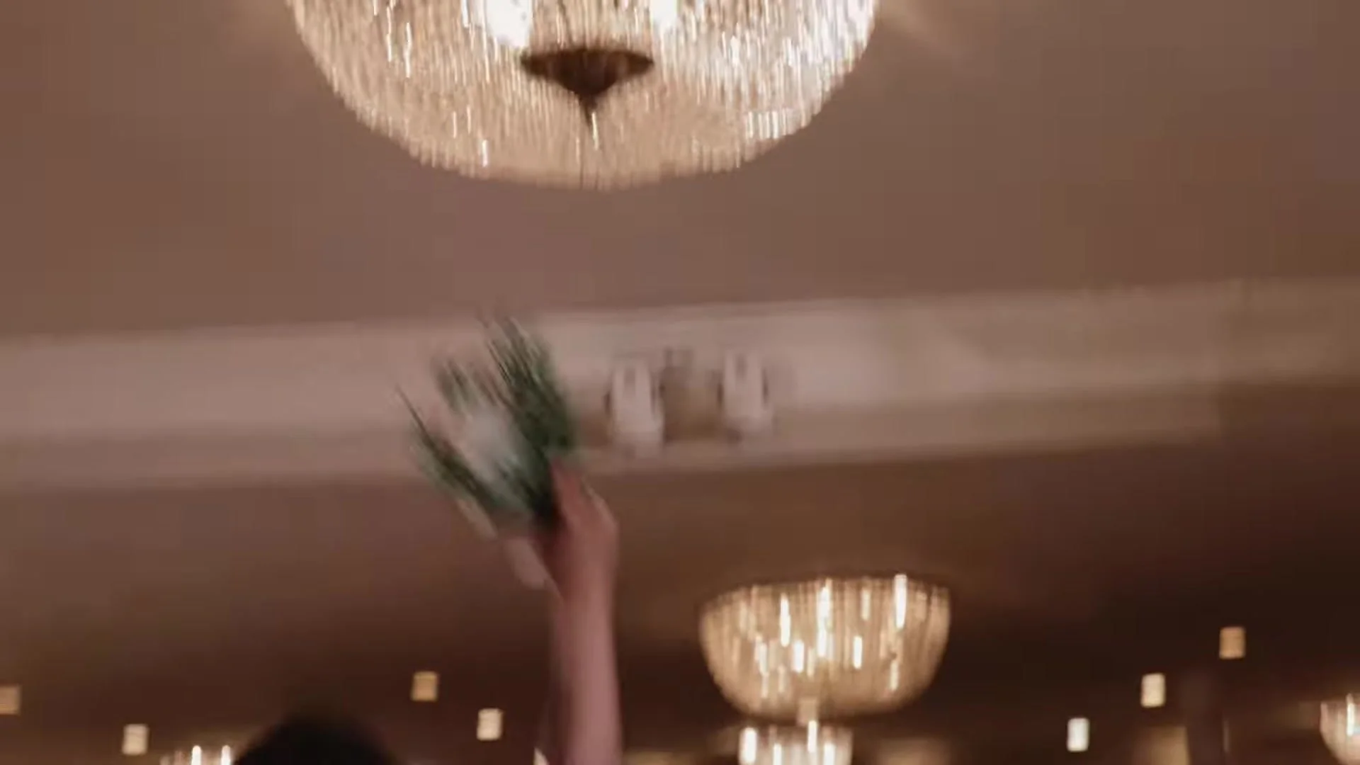 Crystal chandeliers and a raised bouquet in motion at the Southern Oaks Plantation reception in New Orleans