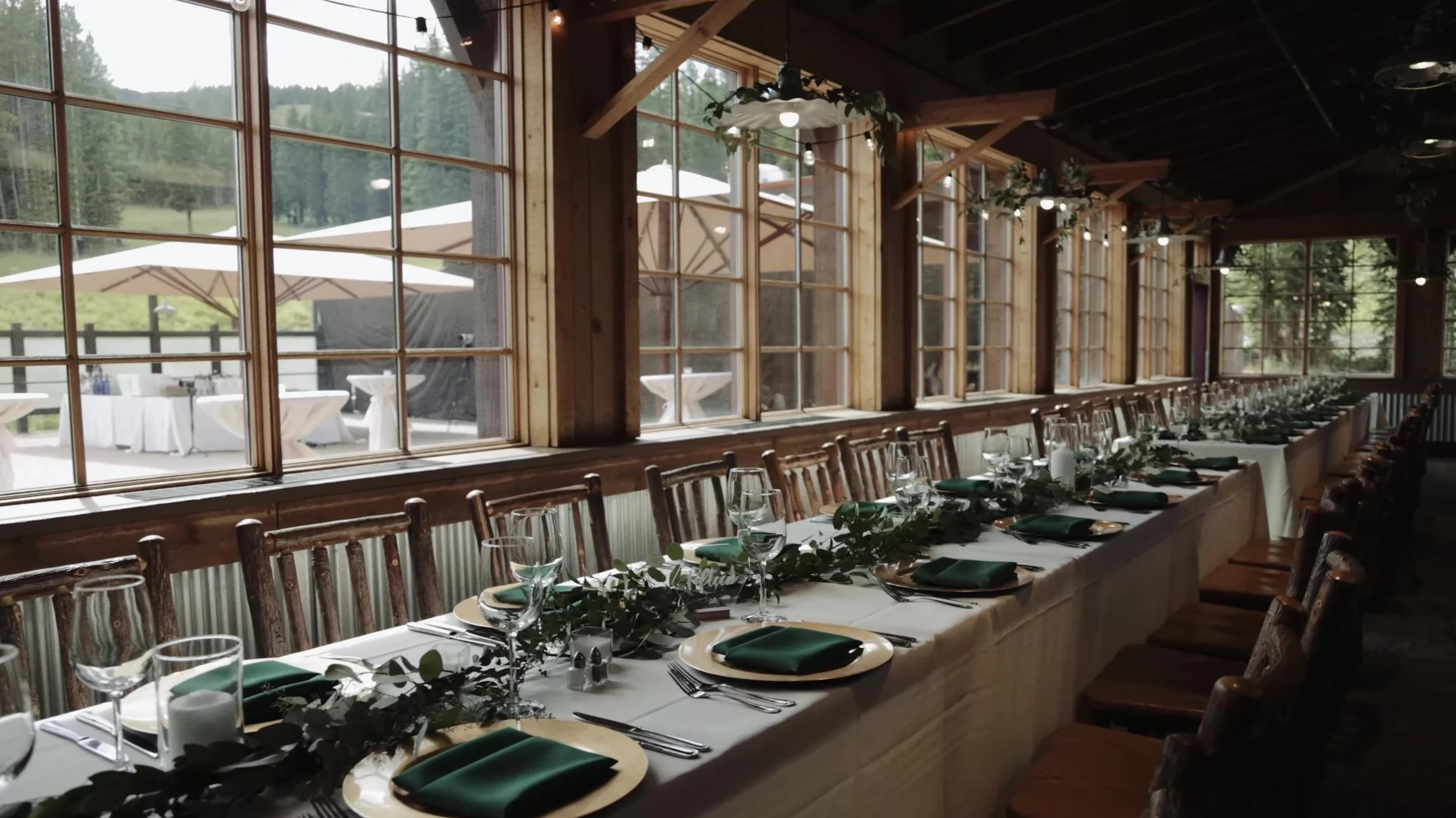 Long reception table with greenery and gold chargers at Ten Mile Station in Breckenridge, Colorado