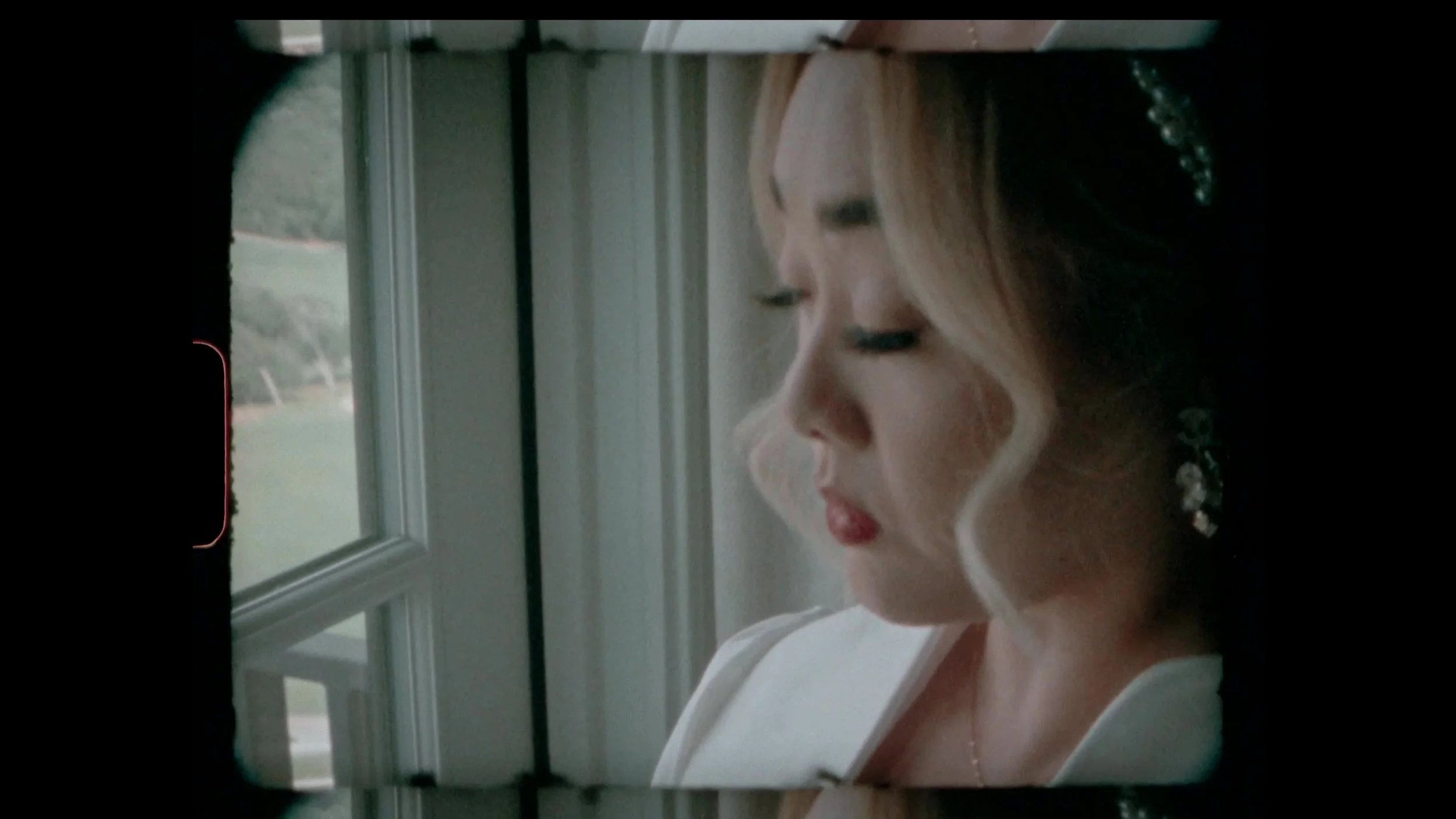 Super 8 grain portrait of Keely in profile at a window at Barton Creek Country Club in Austin
