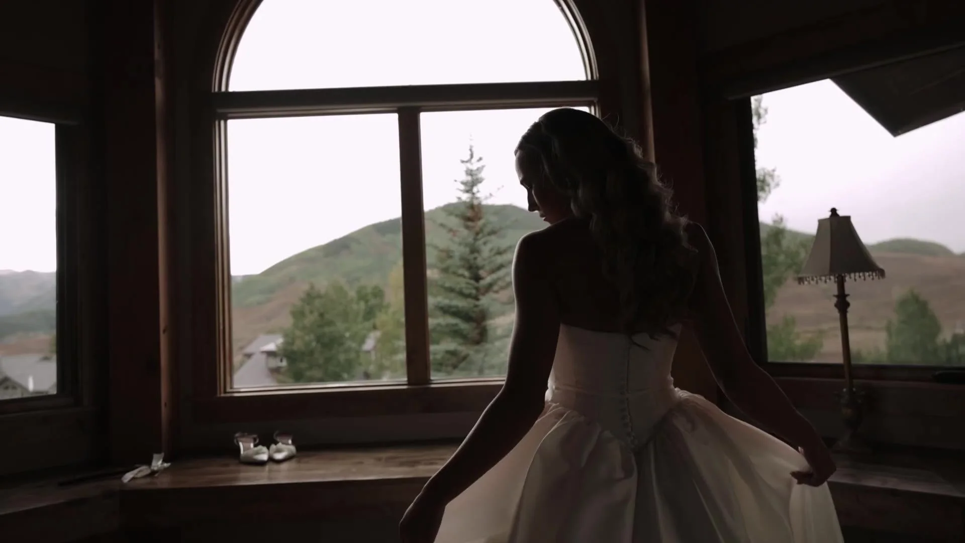 Bride in silhouette at an arched window looking over the Colorado mountains near Crested Butte