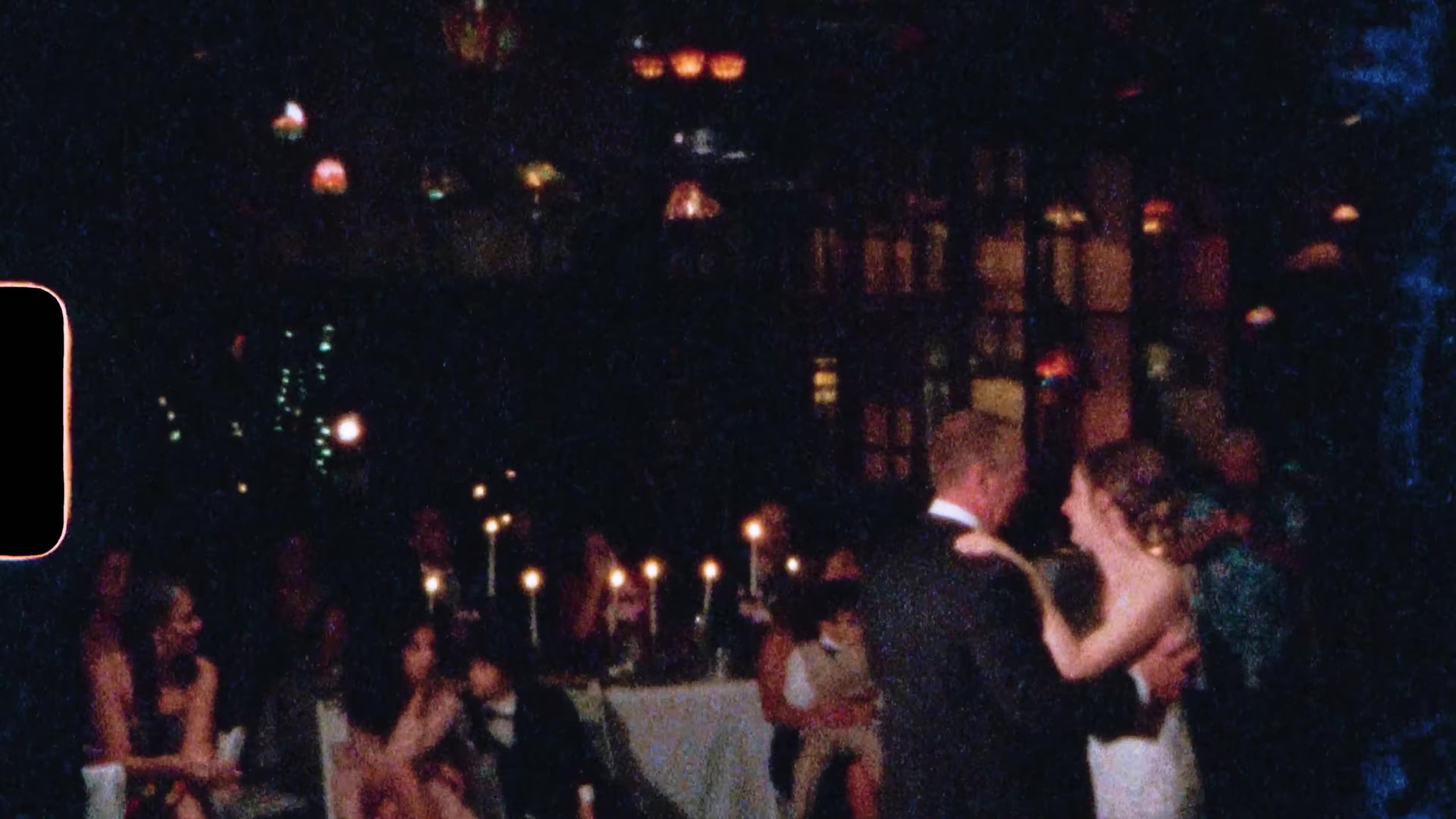 Film frame of the couple dancing under Tiffany lamps at Nouveau Antique Art Venue in Houston, sprocket edge visible