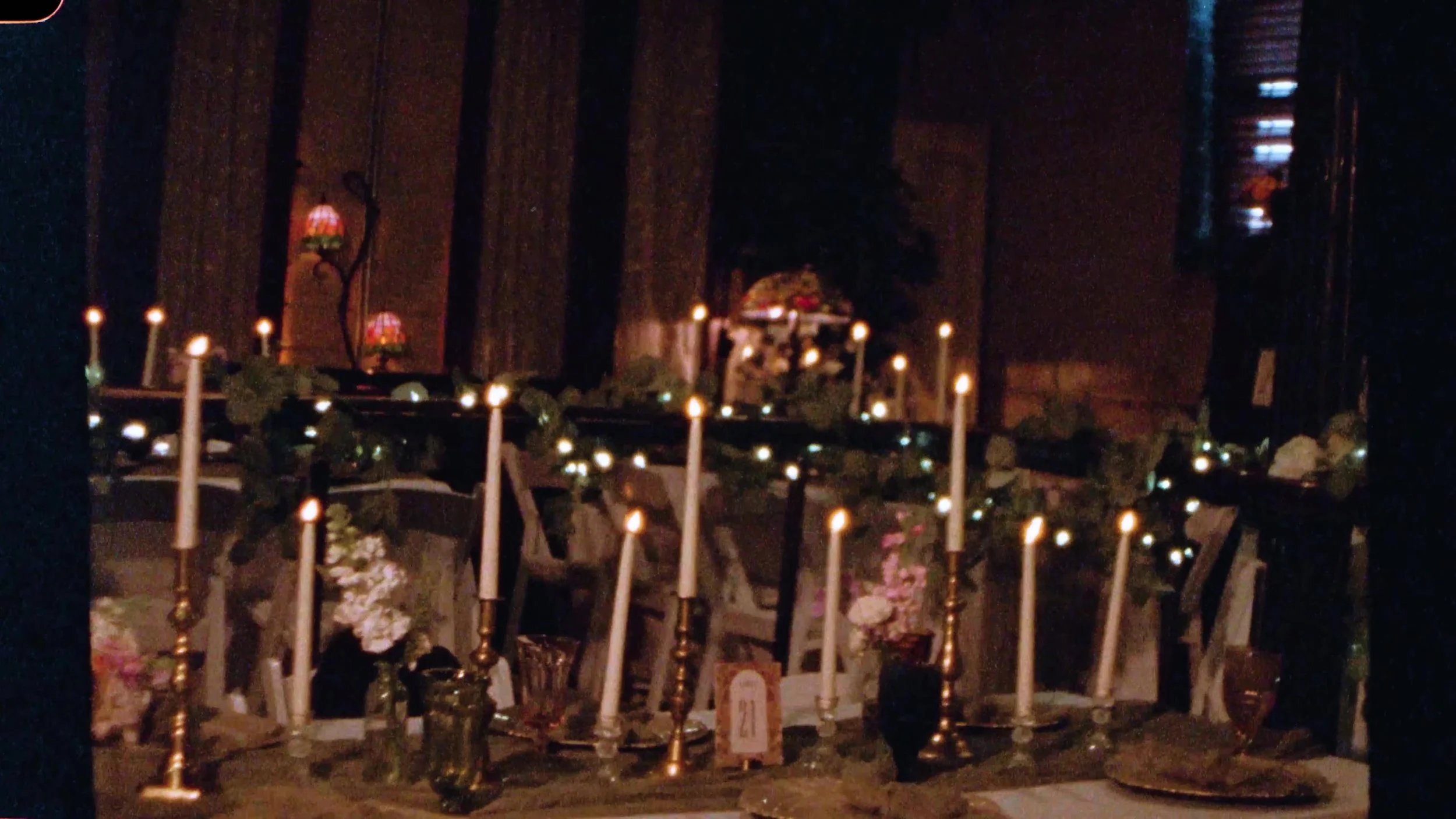 Candlelit reception table with flowers and Tiffany lamps at Nouveau Antique Art Venue in Houston, Texas