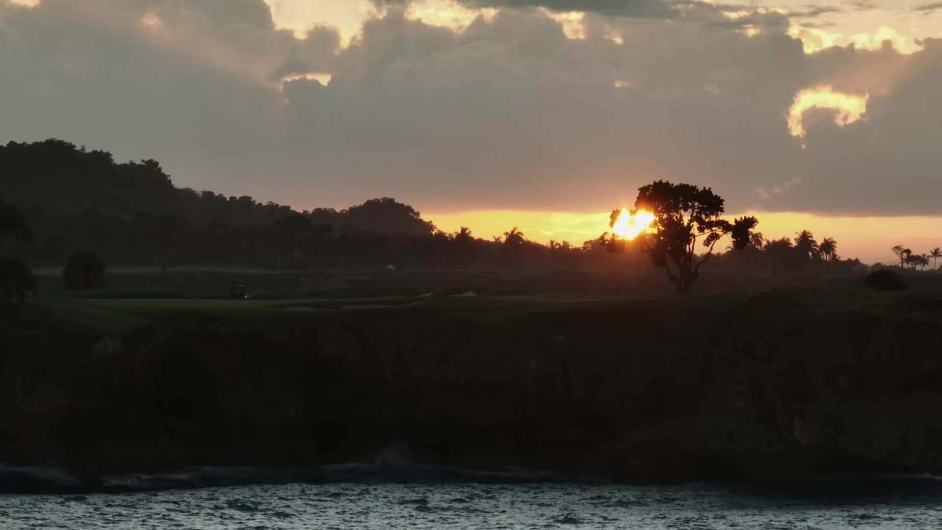 Sunset silhouette of trees and hills over water near Amanera Dominican Republic