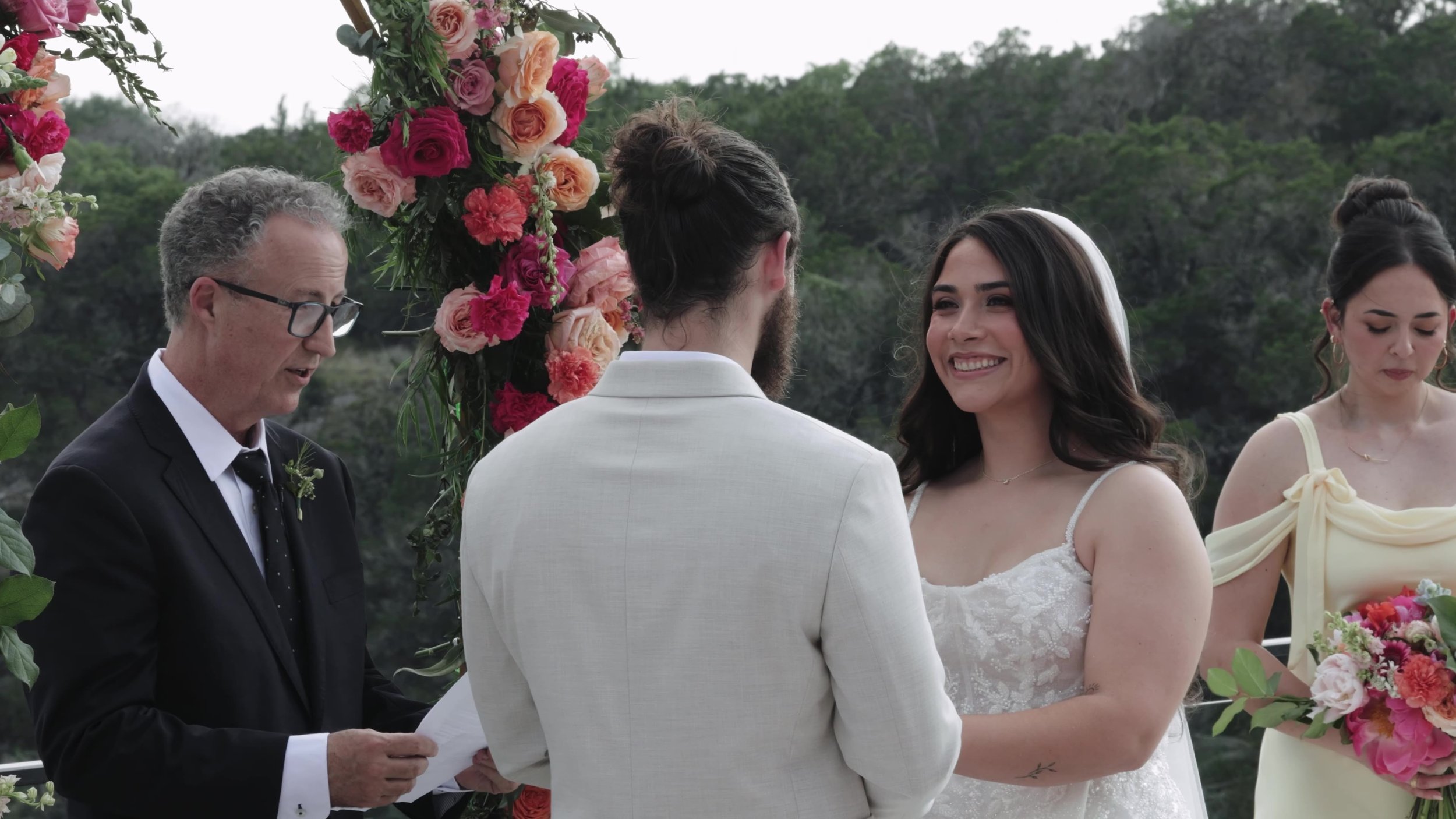Peter and Kiyara exchanging vows under the floral arch at Videre Estate Austin Texas Hill Country