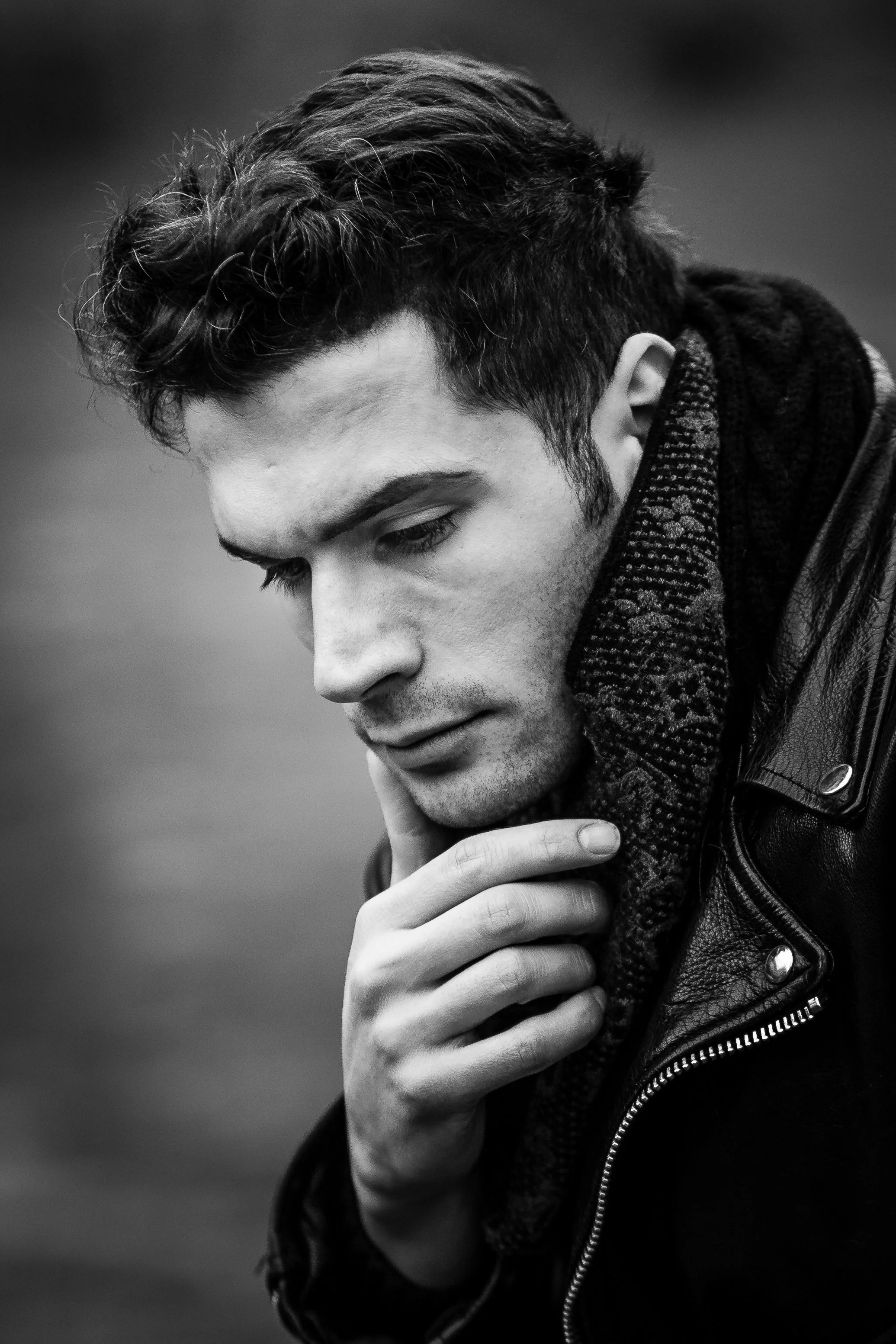 Soft black and white portrait looking down in thought.