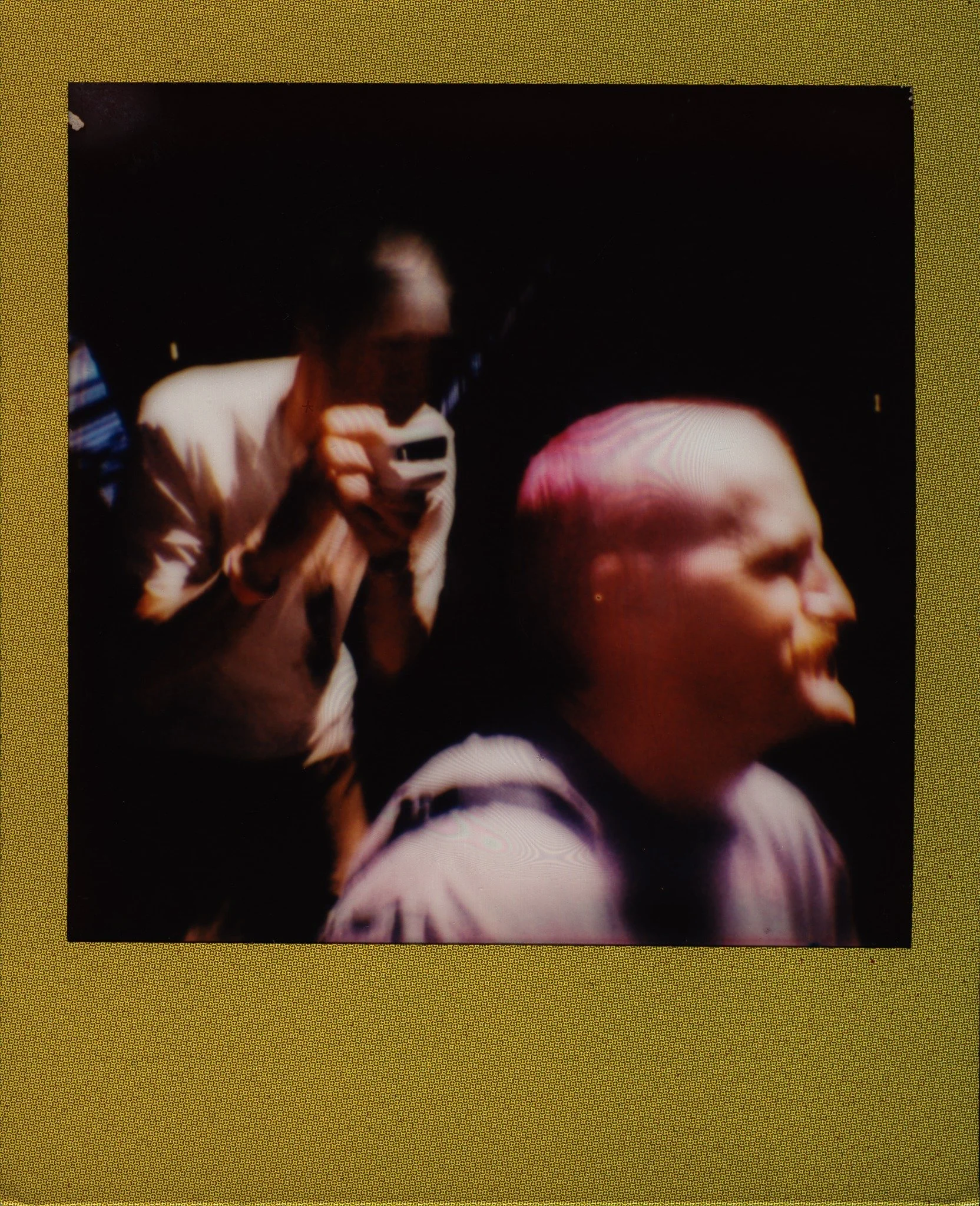 Two people passing through an instant photograph