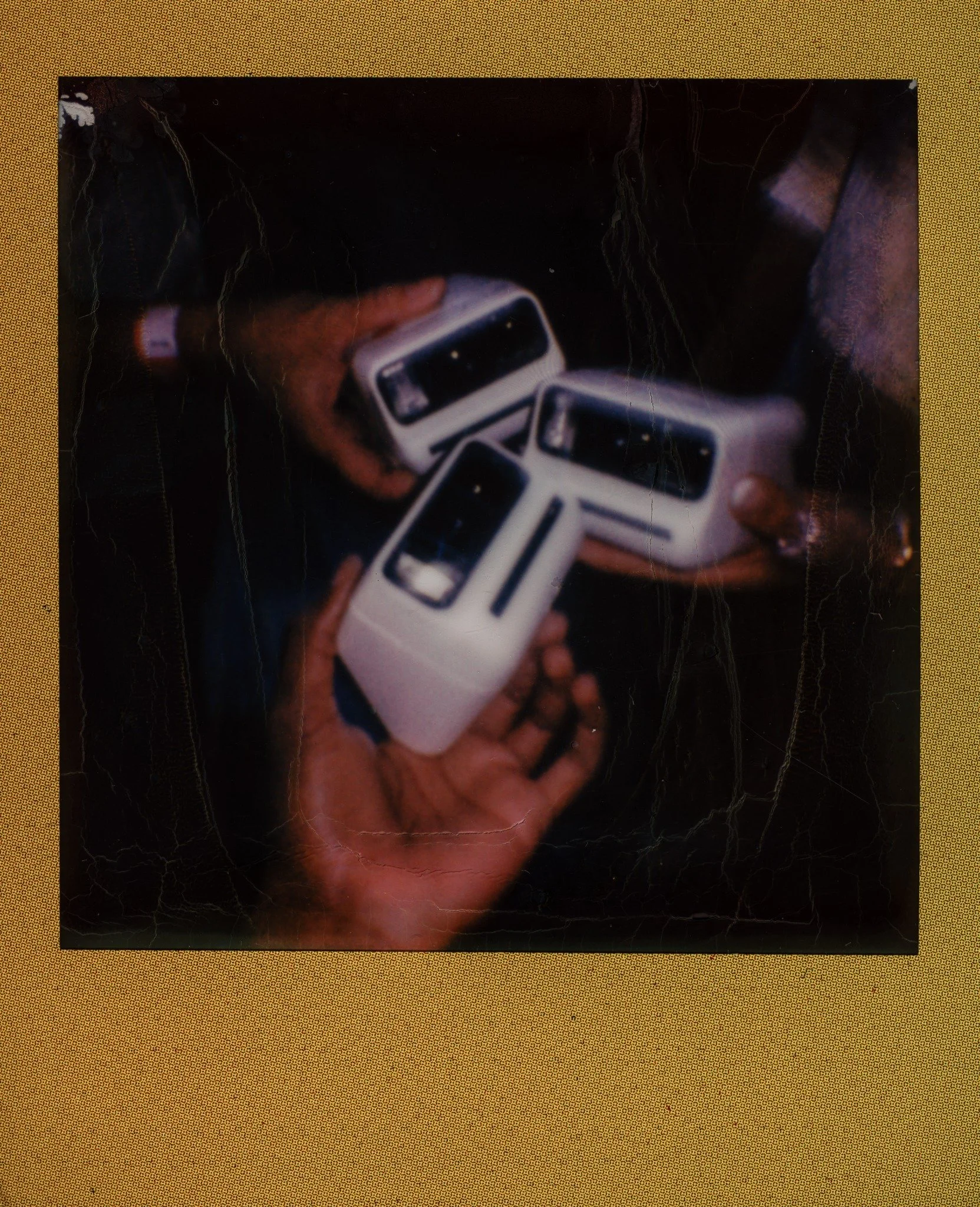 Hands holding instant cameras