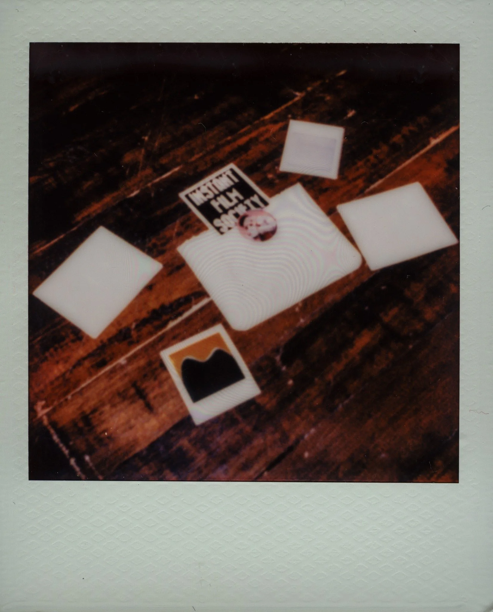 Instant prints arranged on a wooden worktable