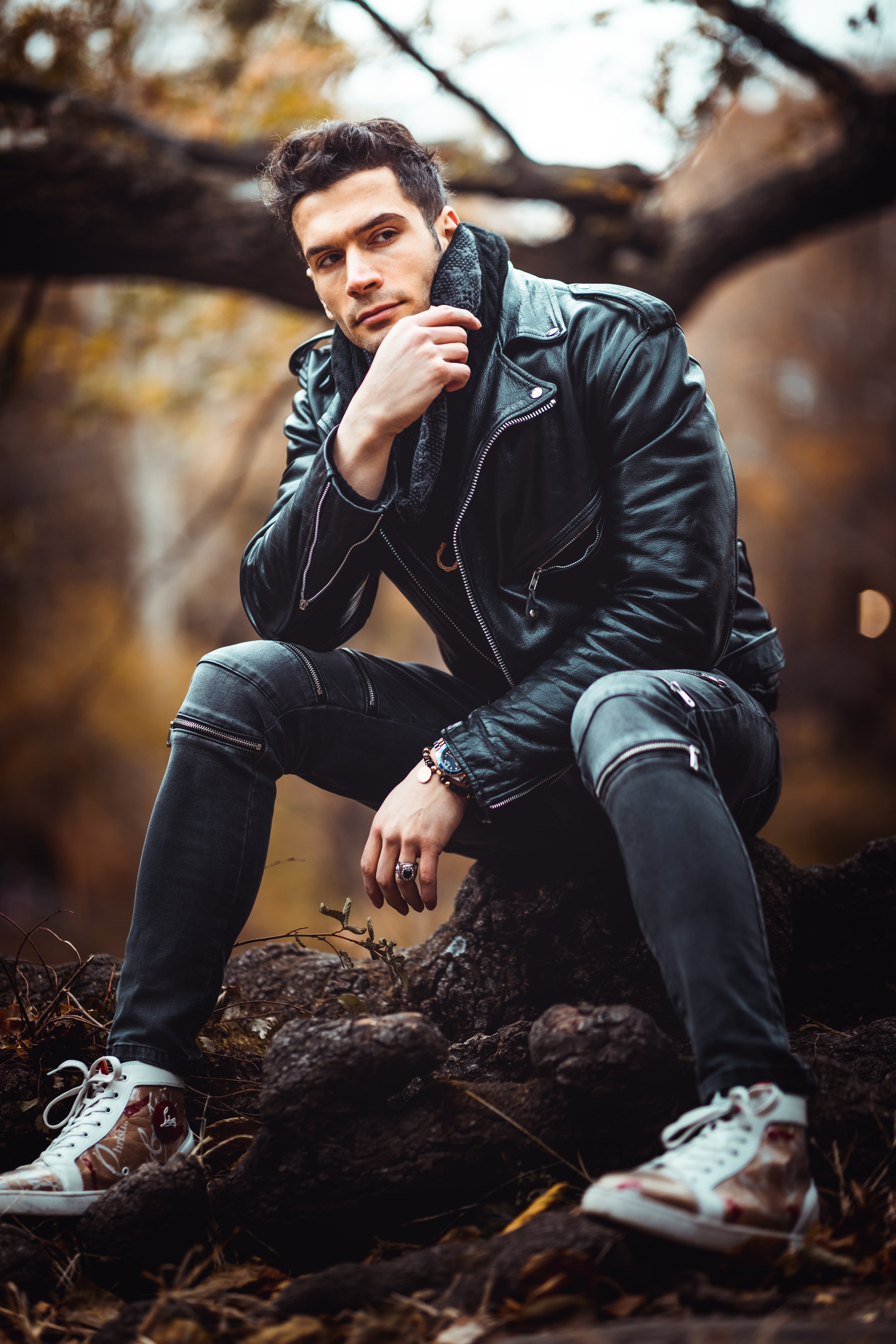 Seated portrait in leather jacket with fall background.