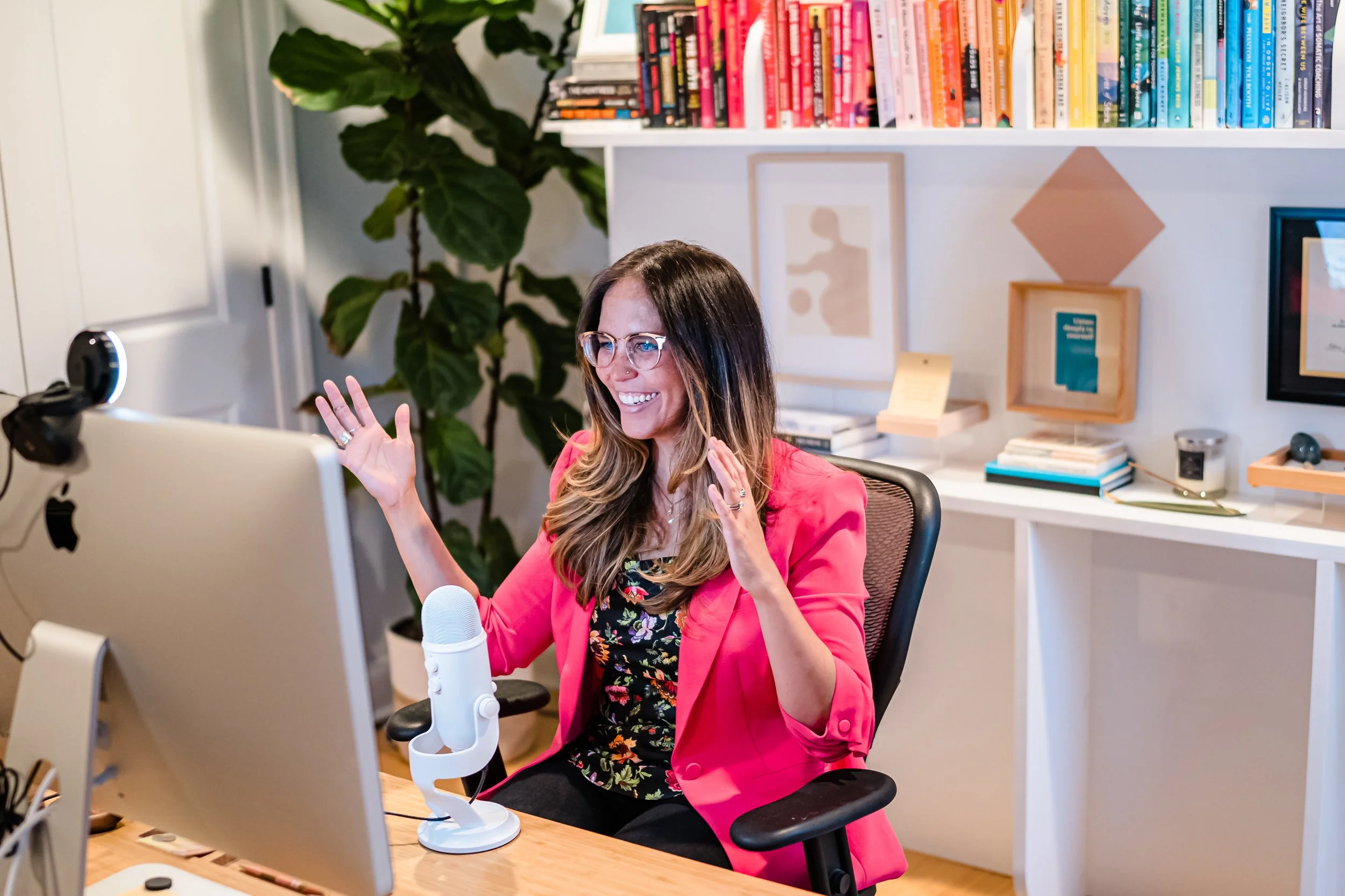 Coral Edwards, founder of IMHMO, standing by her bookshelf