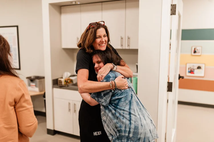 Heidi hugging a Citizen in Room 210