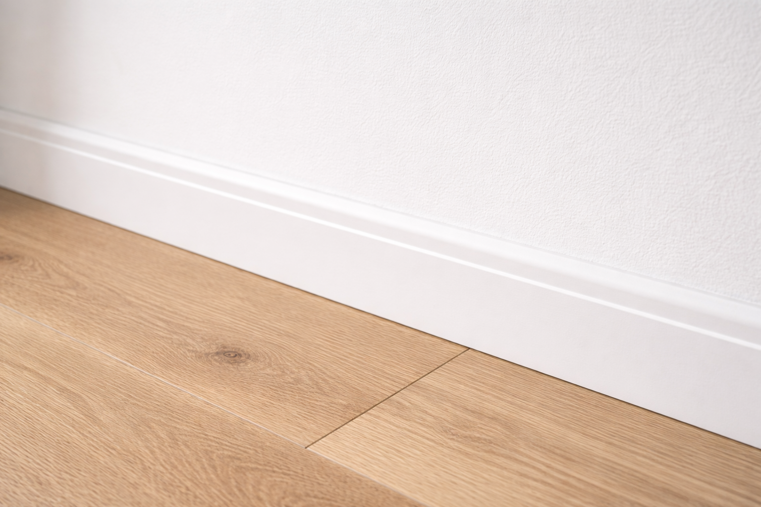 Witte plinten langs muur - strakke afwerking vloer-muur overgang