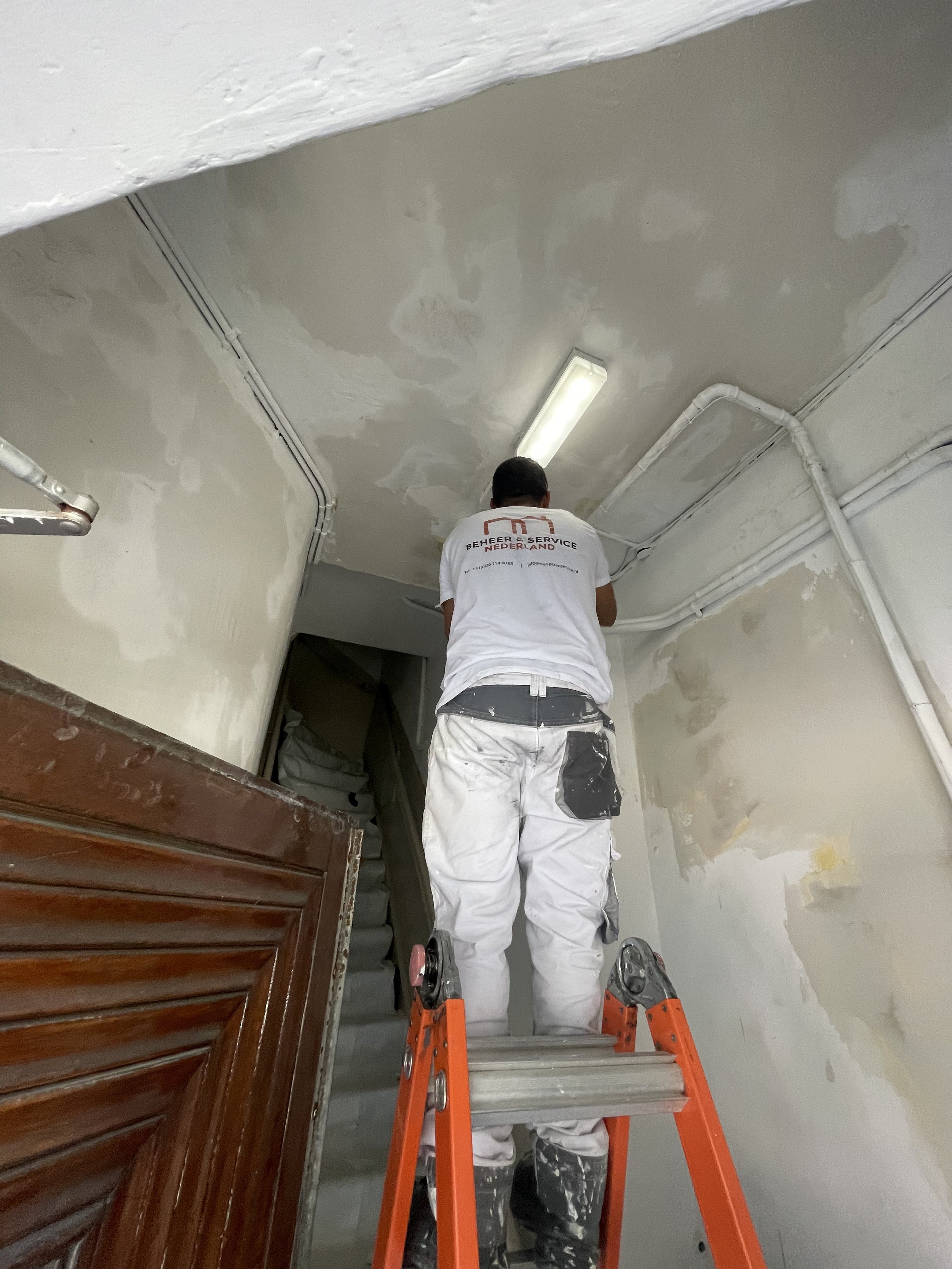 Stukadoor werkt een wand glad af in een woning in Amstelveen