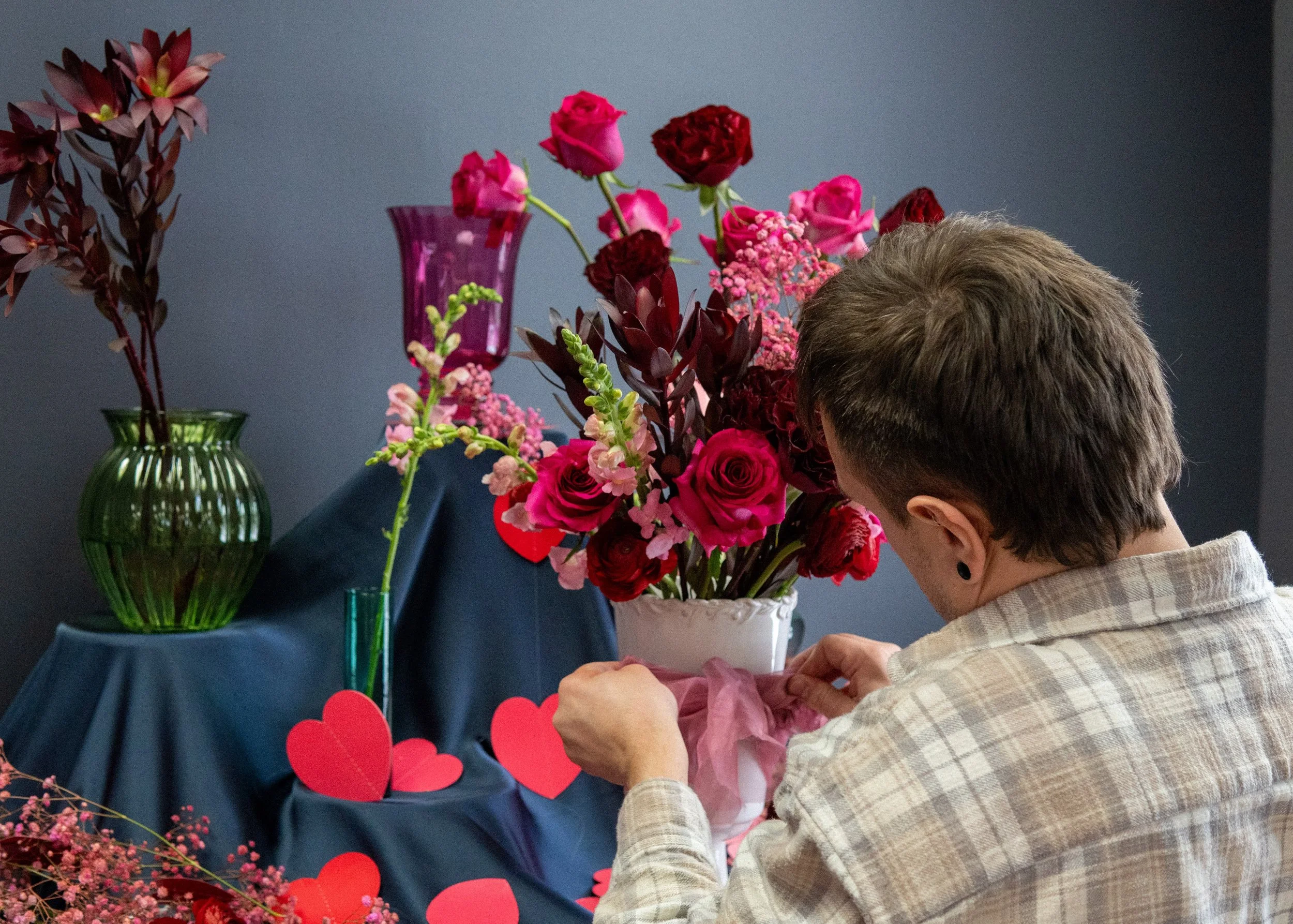 Ed adding details to a colorful floral arrangement in the studio.